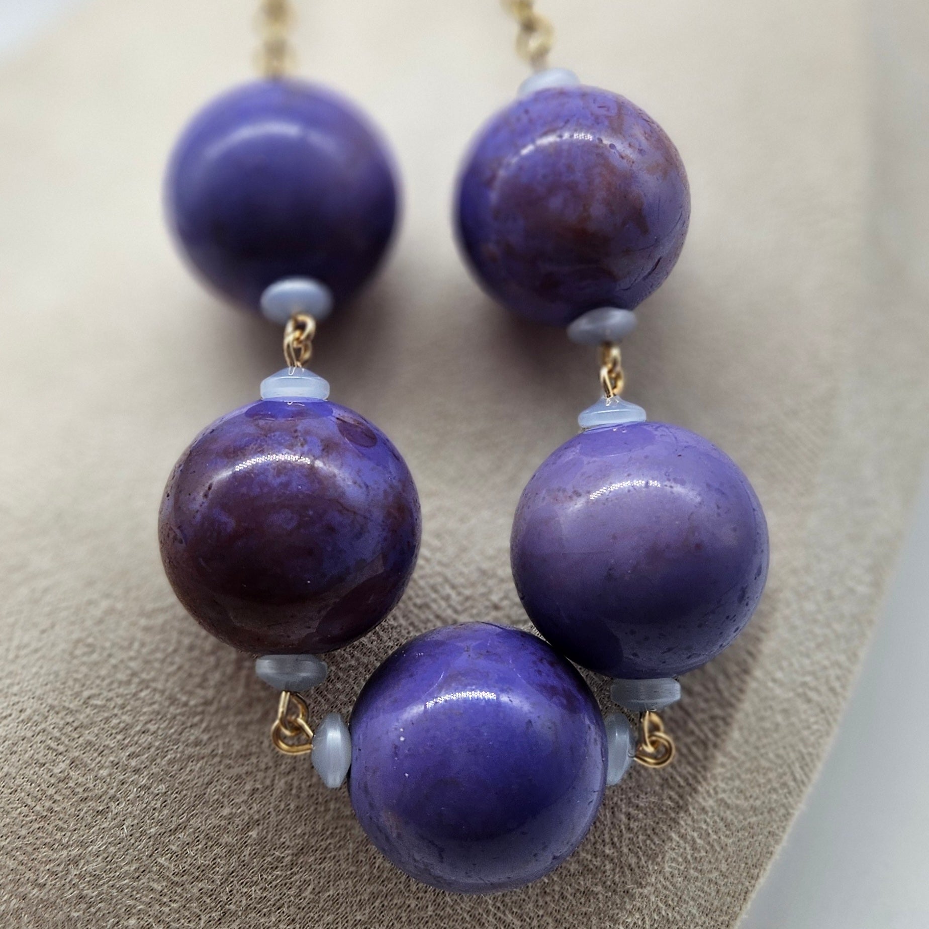 Purple beaded necklace on a beige surface