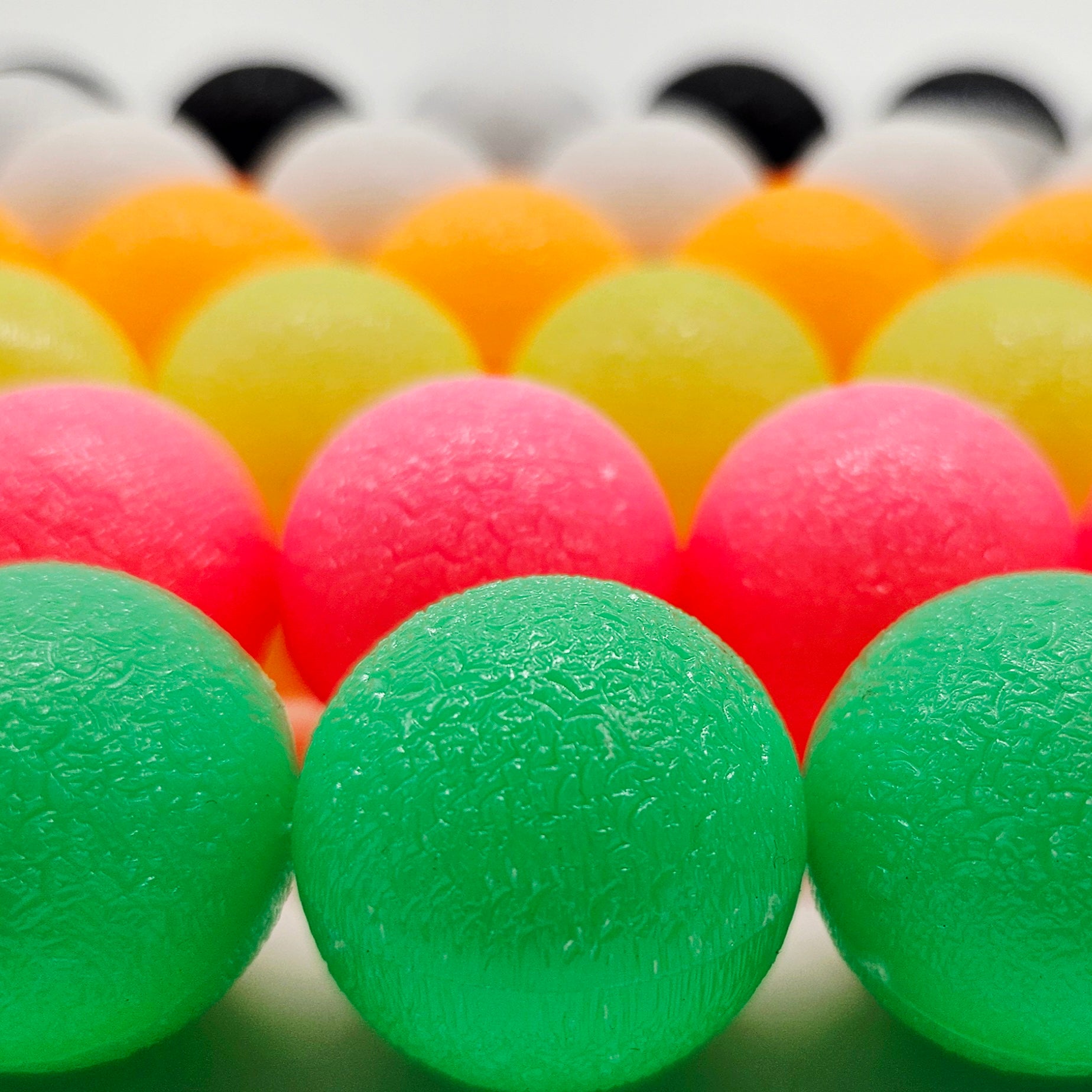 Close-up of colorful textured beads including green, pink, orange, and yellow.