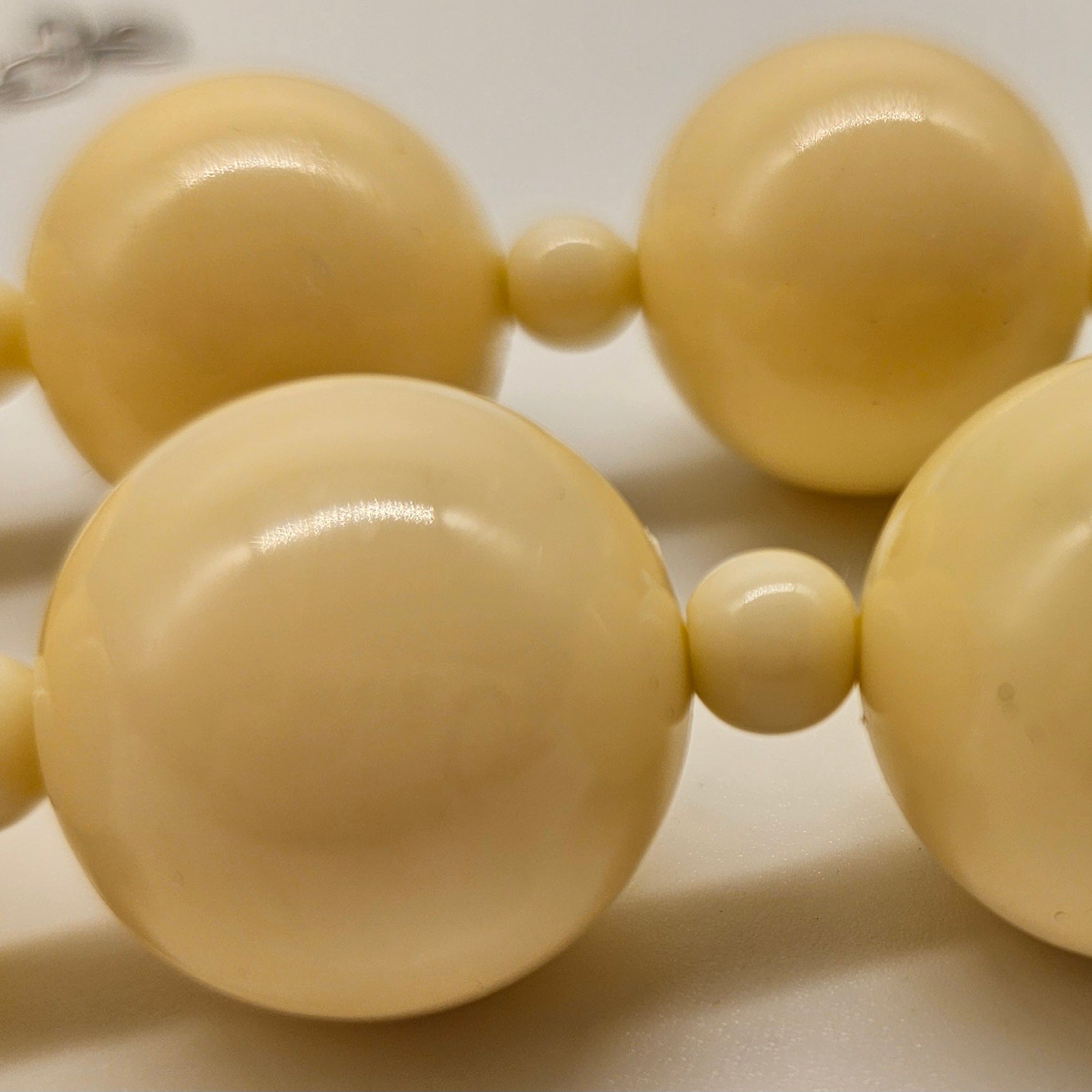 Close-up of a beige beaded necklace on a light background