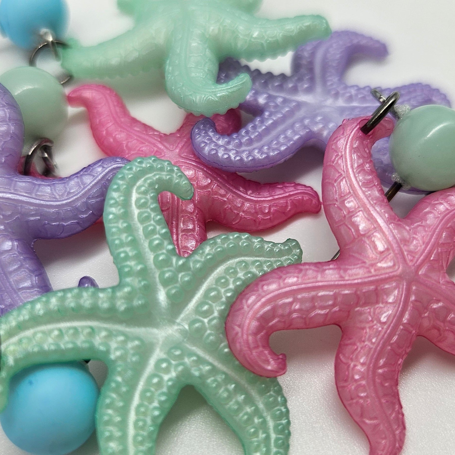 Colorful starfish earrings on a white background