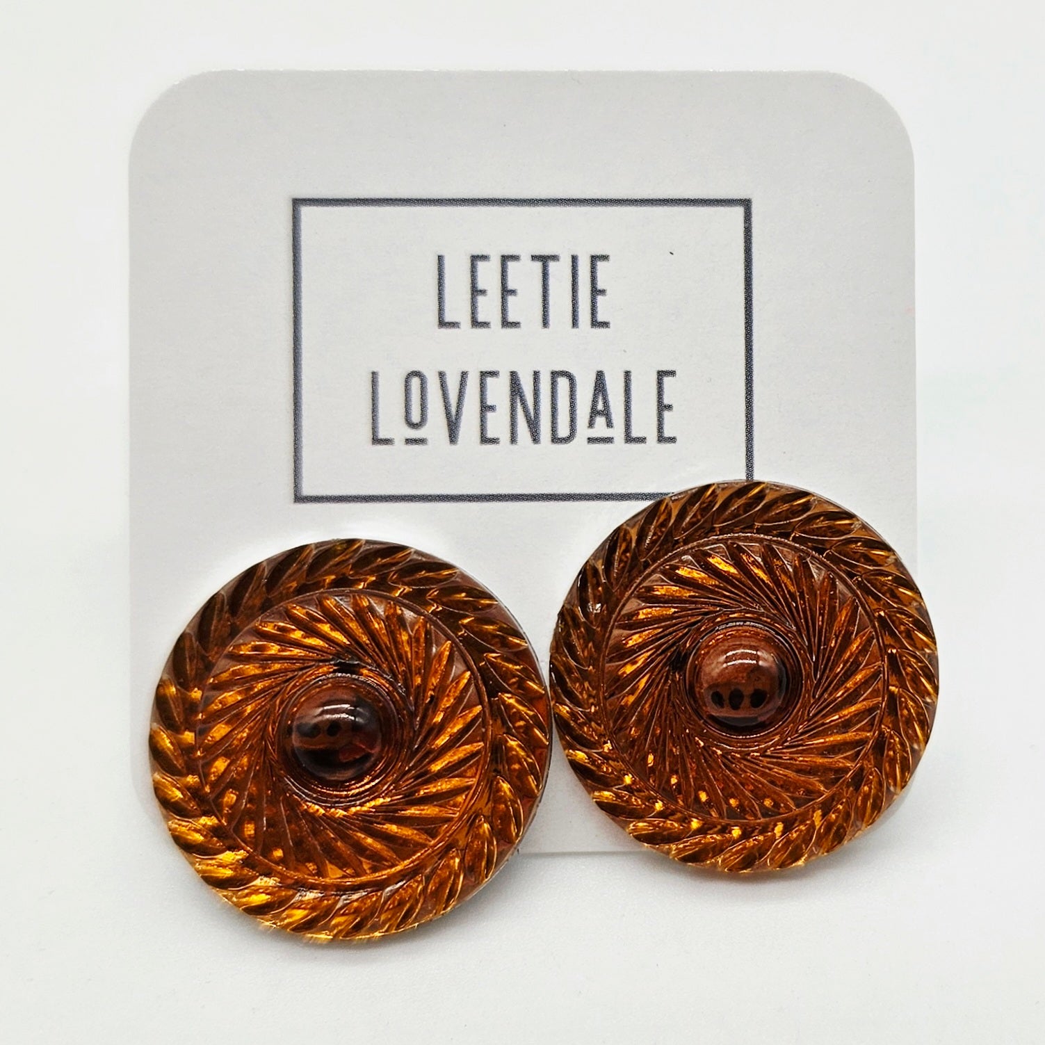 Pair of orange earrings on a &