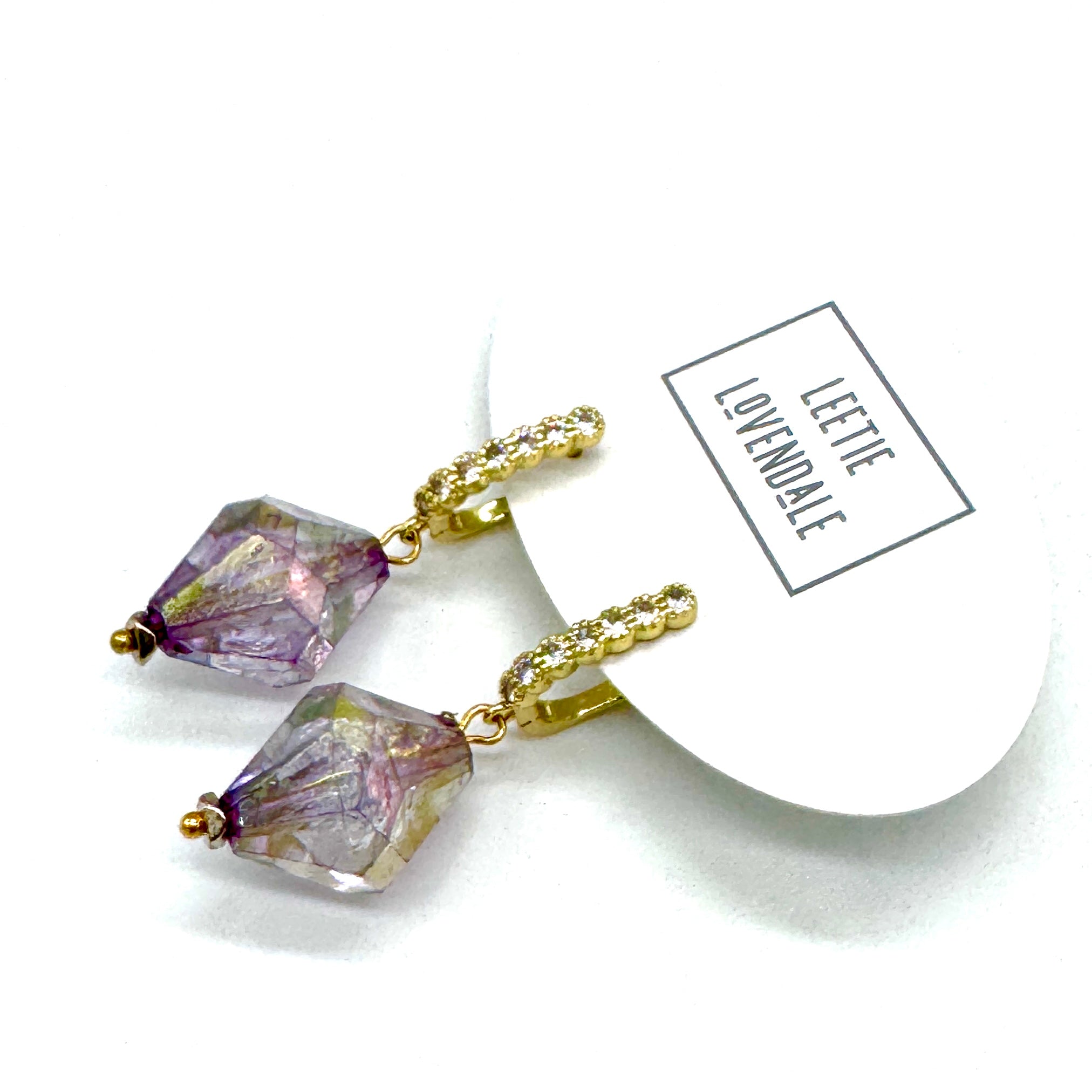 Purple crystal earrings with gold accents on a white background, featuring a &