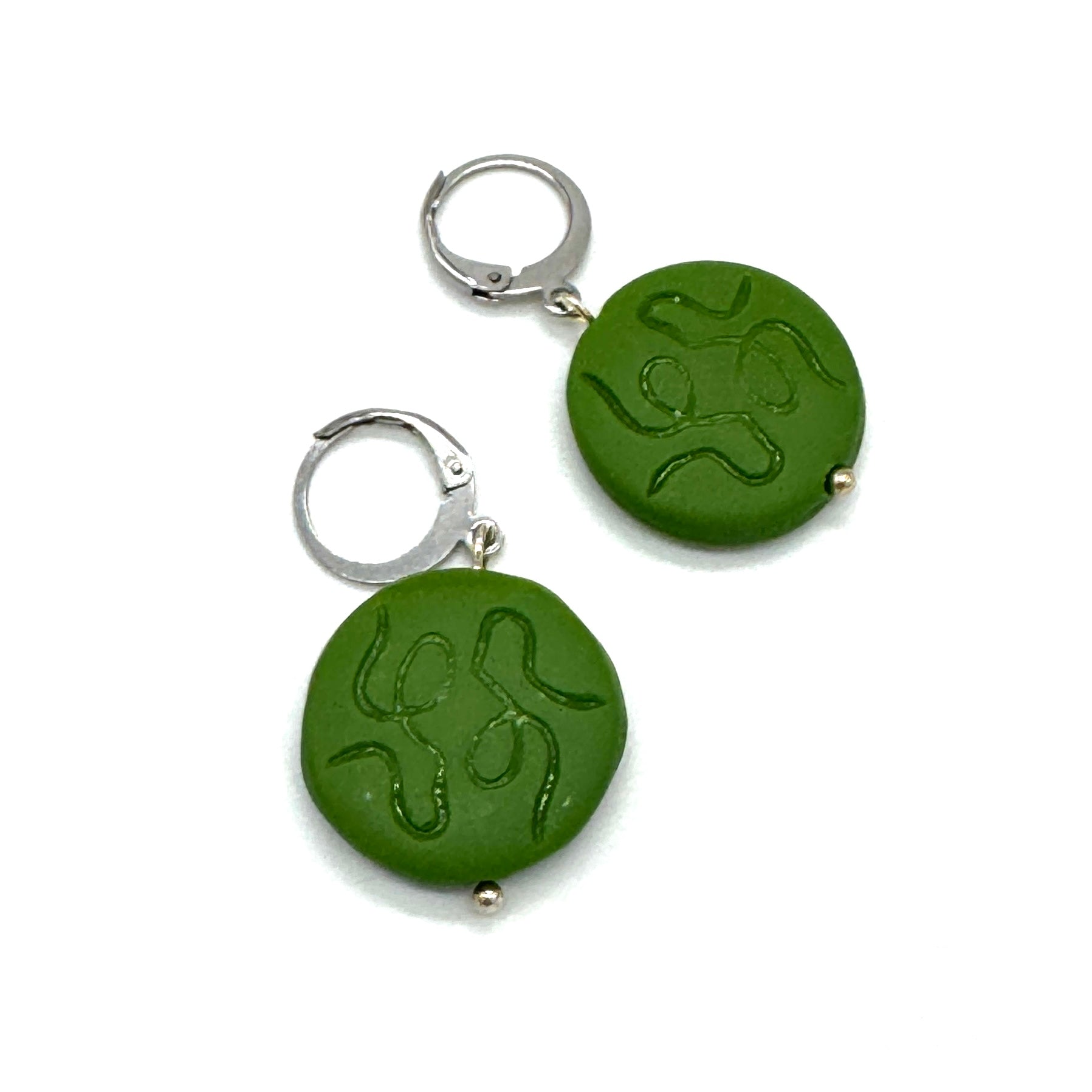 Green round earrings with silver hooks on a white background
