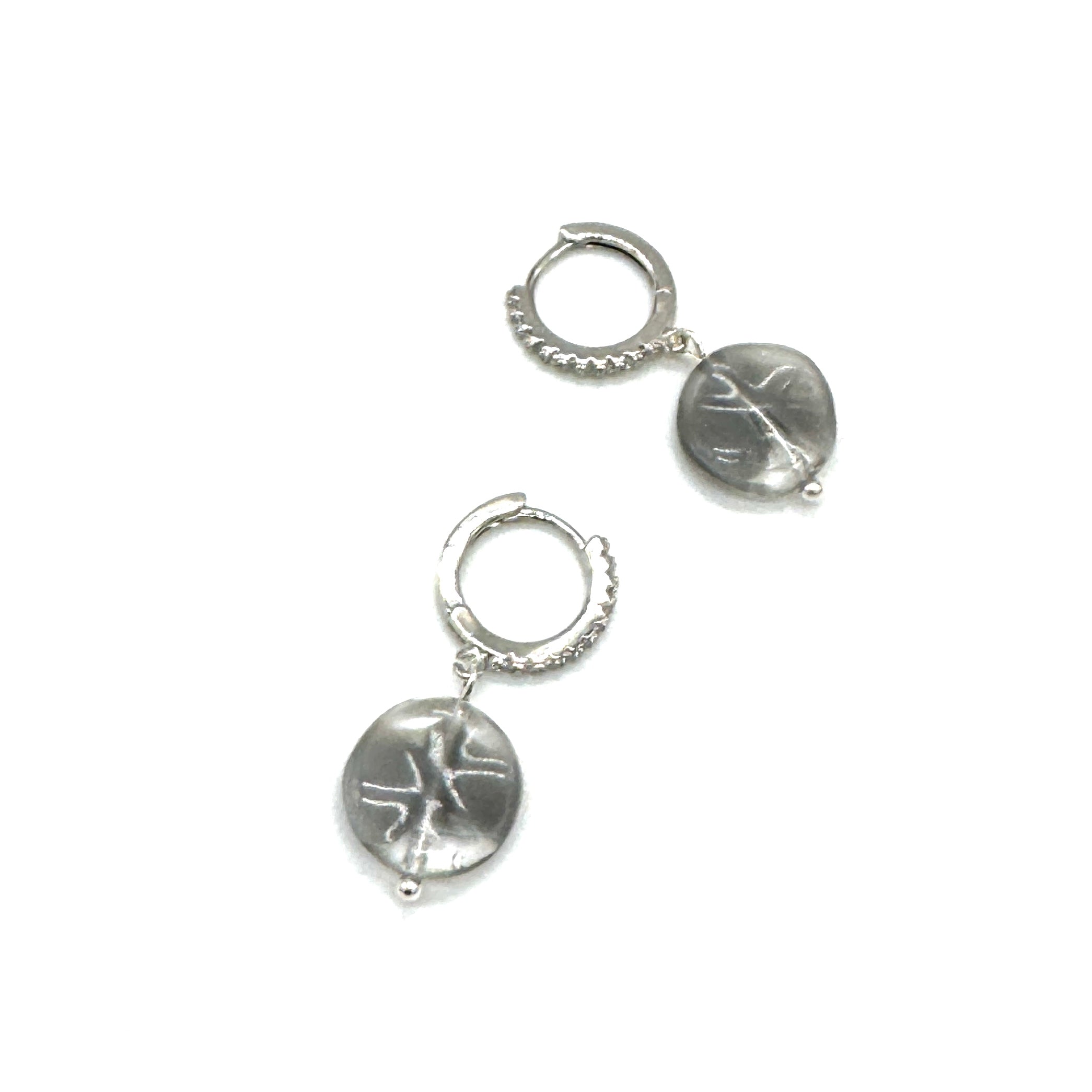 Pair of silver hoop earrings with engraved designs on a white background
