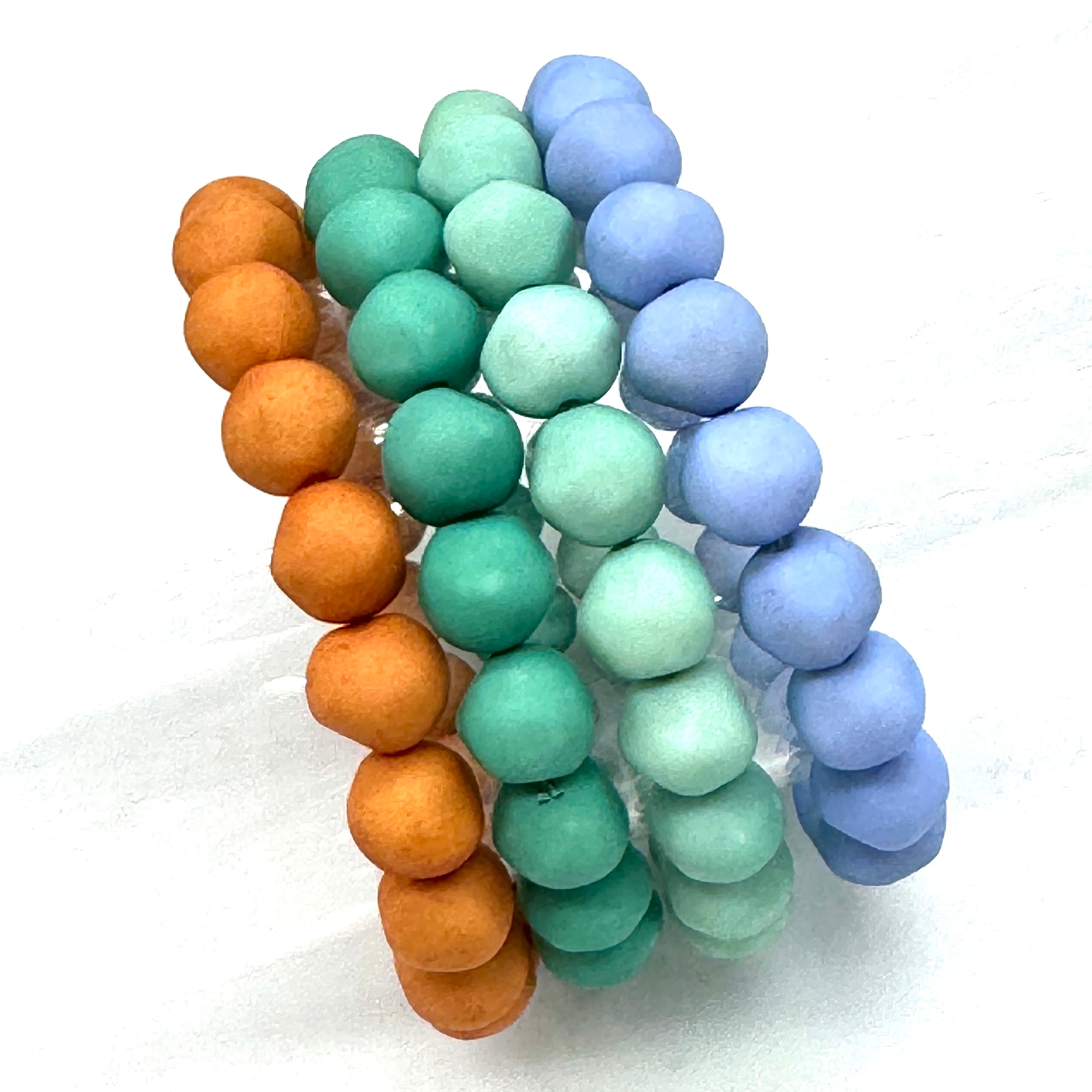 Set of four lucite beaded bracelets in orange, teal, turquoise, and periwinkle