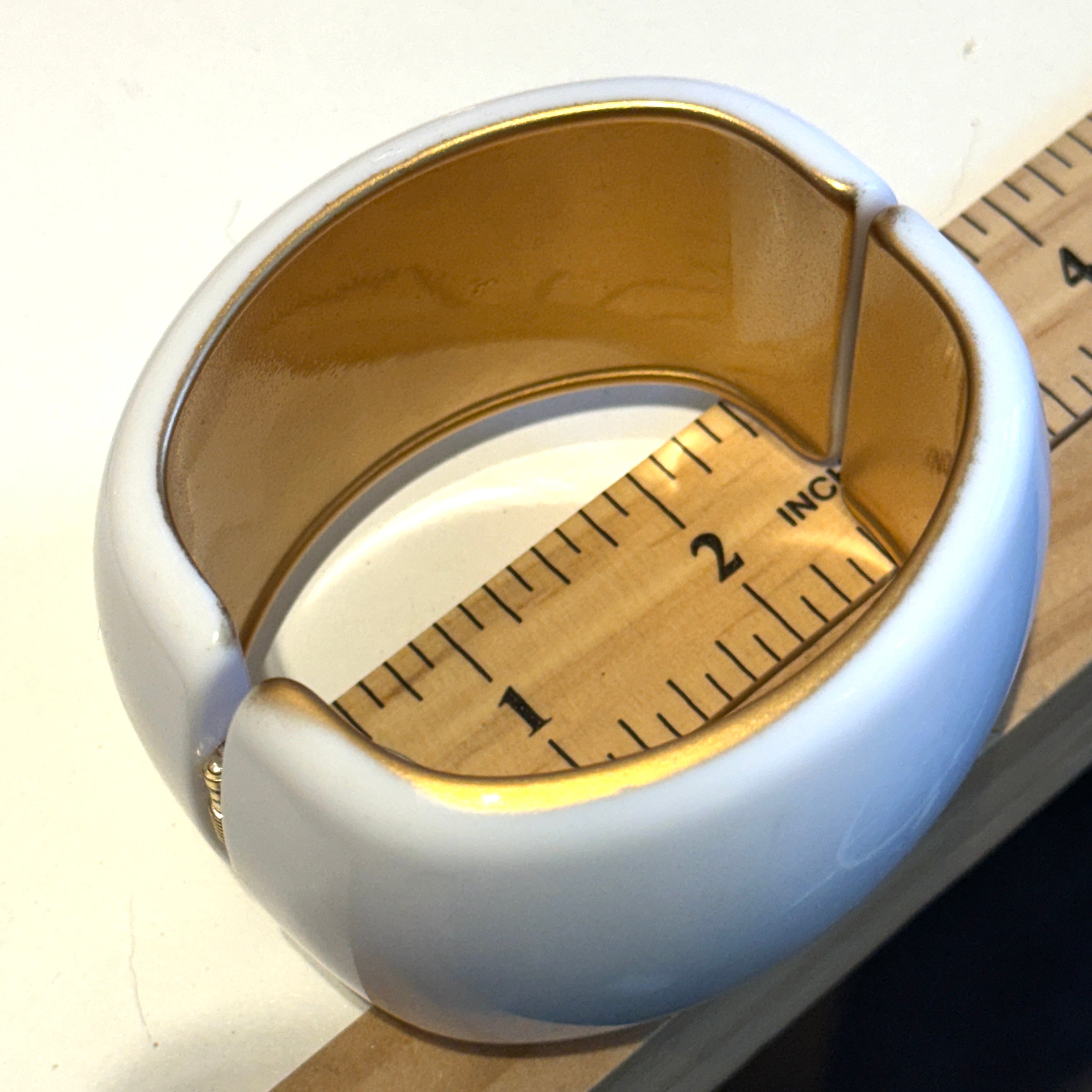 white lucite clamper cuff bracelet on a ruler