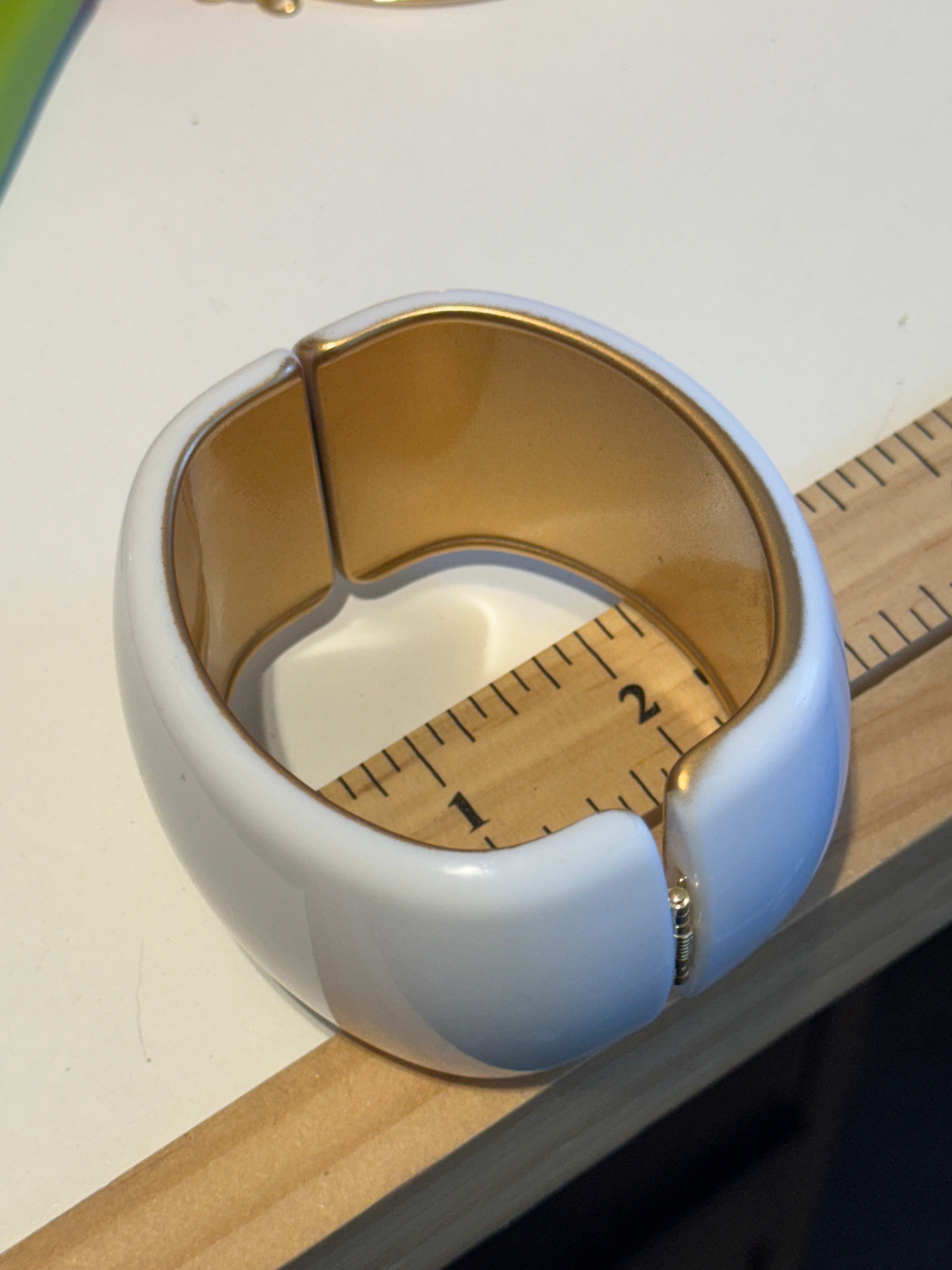 white lucite clamper cuff bracelet on a ruler