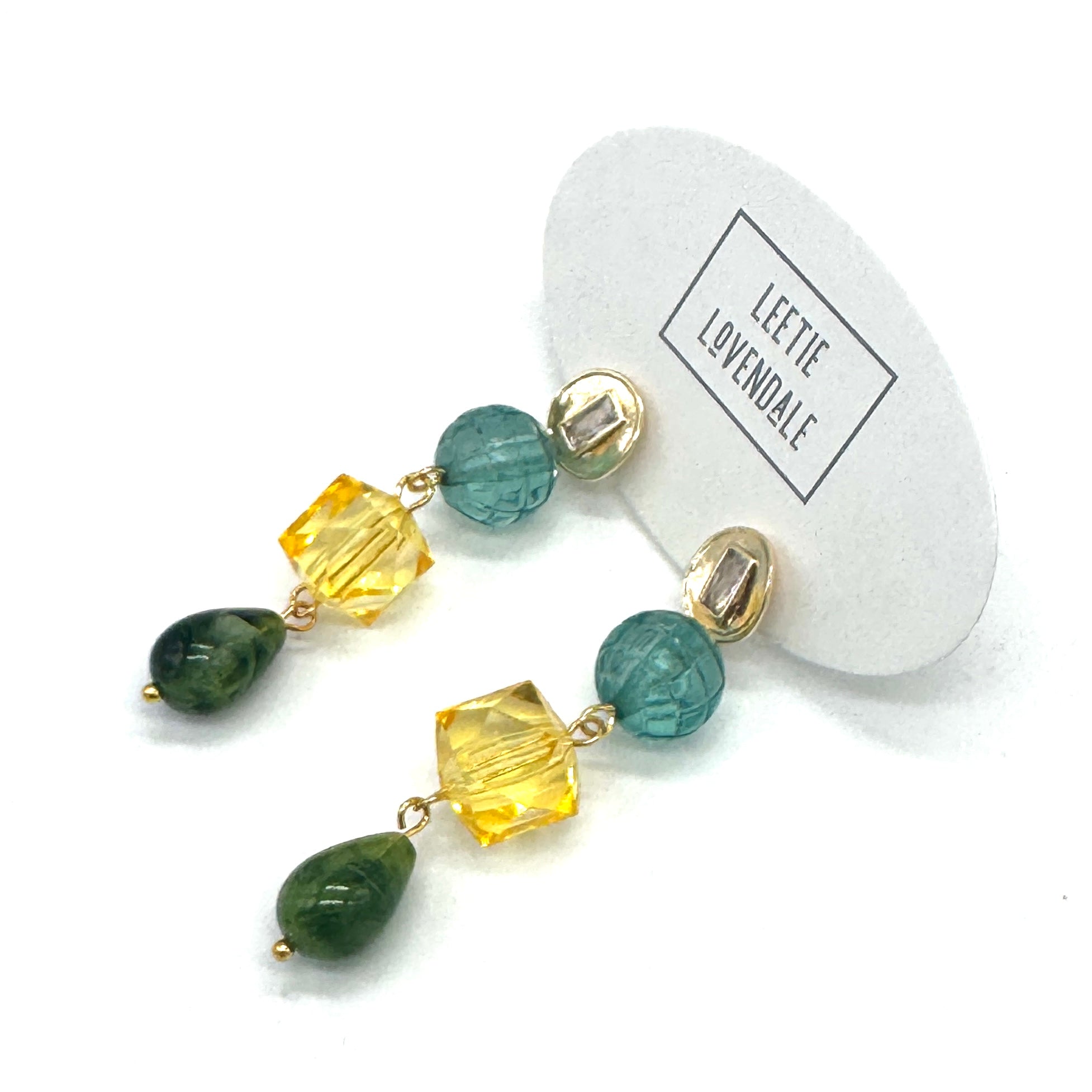 Beaded earrings with green and yellow stones on a white background