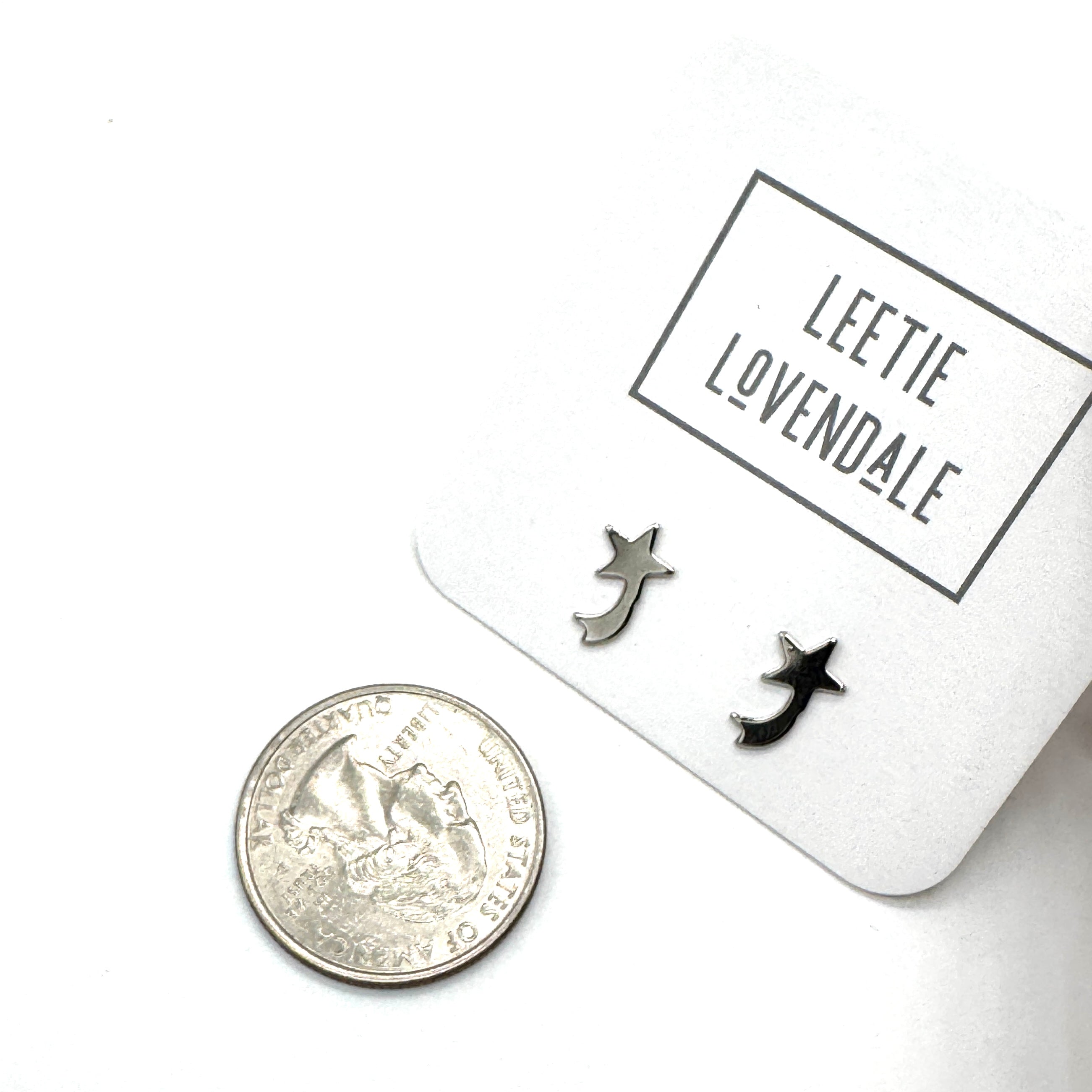 Silver shooting star earrings on a white card with &