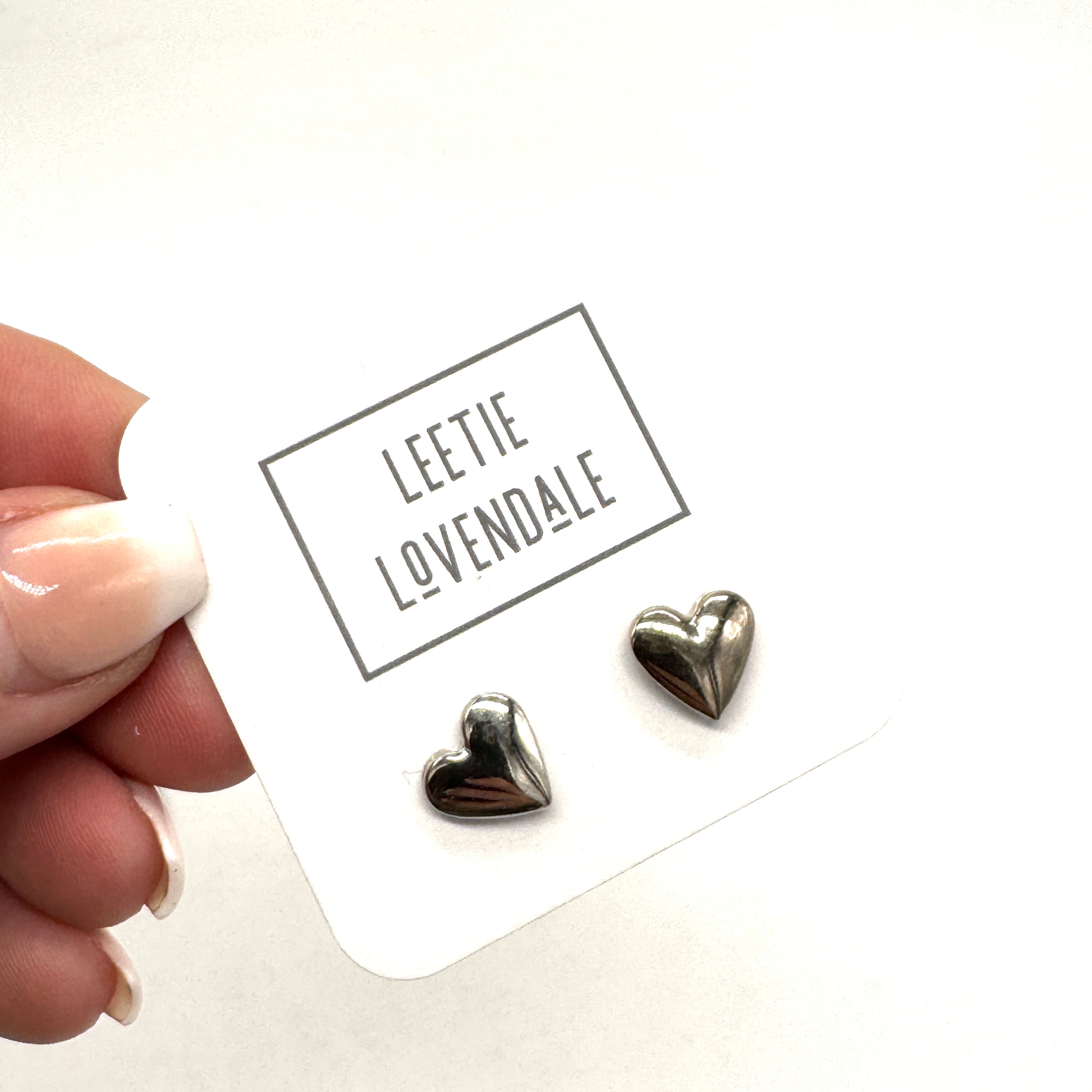 Heart-shaped earrings on a card with &