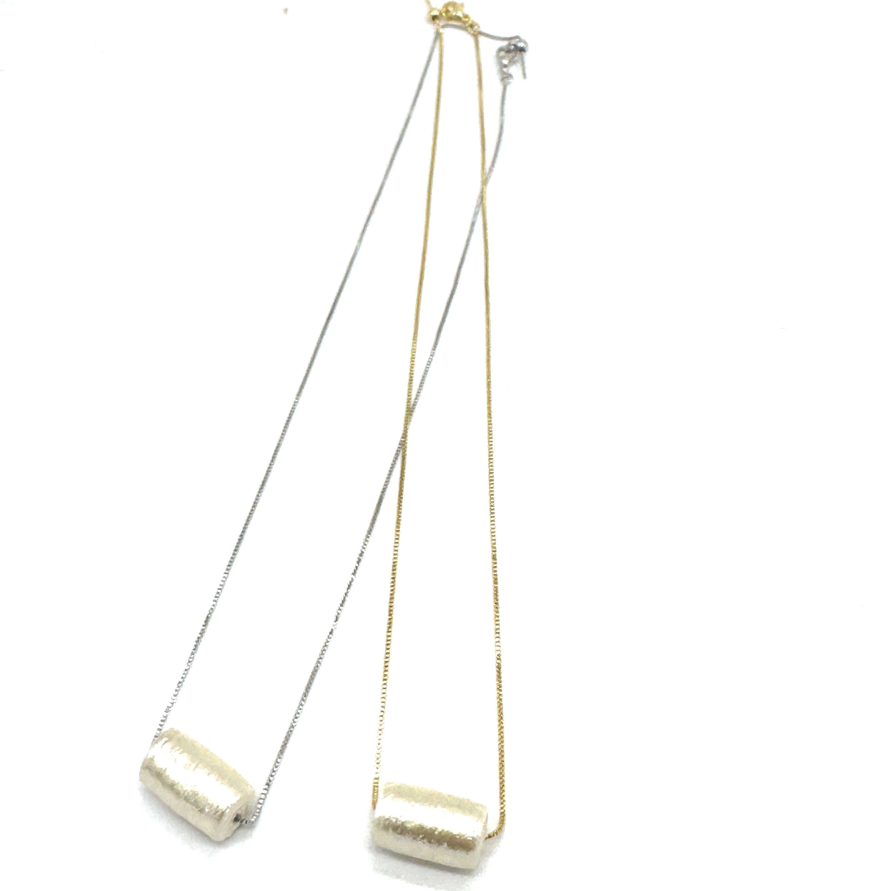 Two necklaces with gold and silver chains on a white background