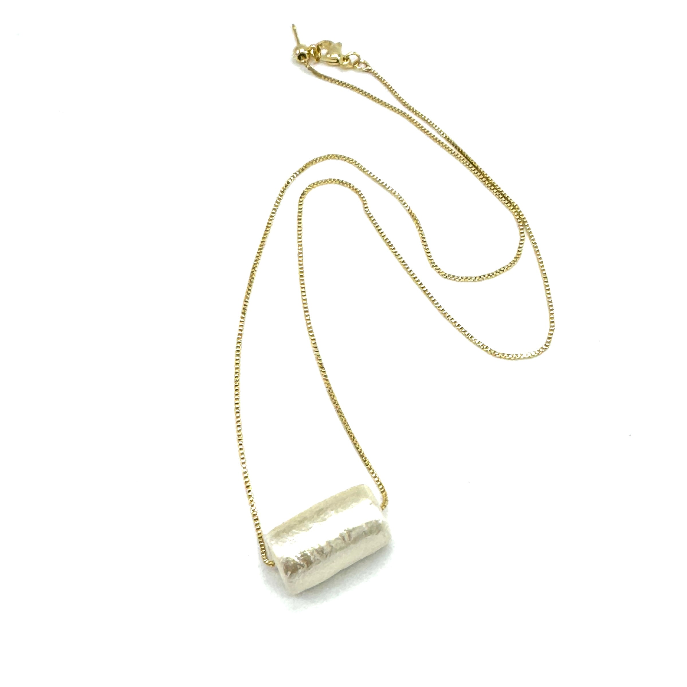 Necklace with a cylindrical pendant on a white background