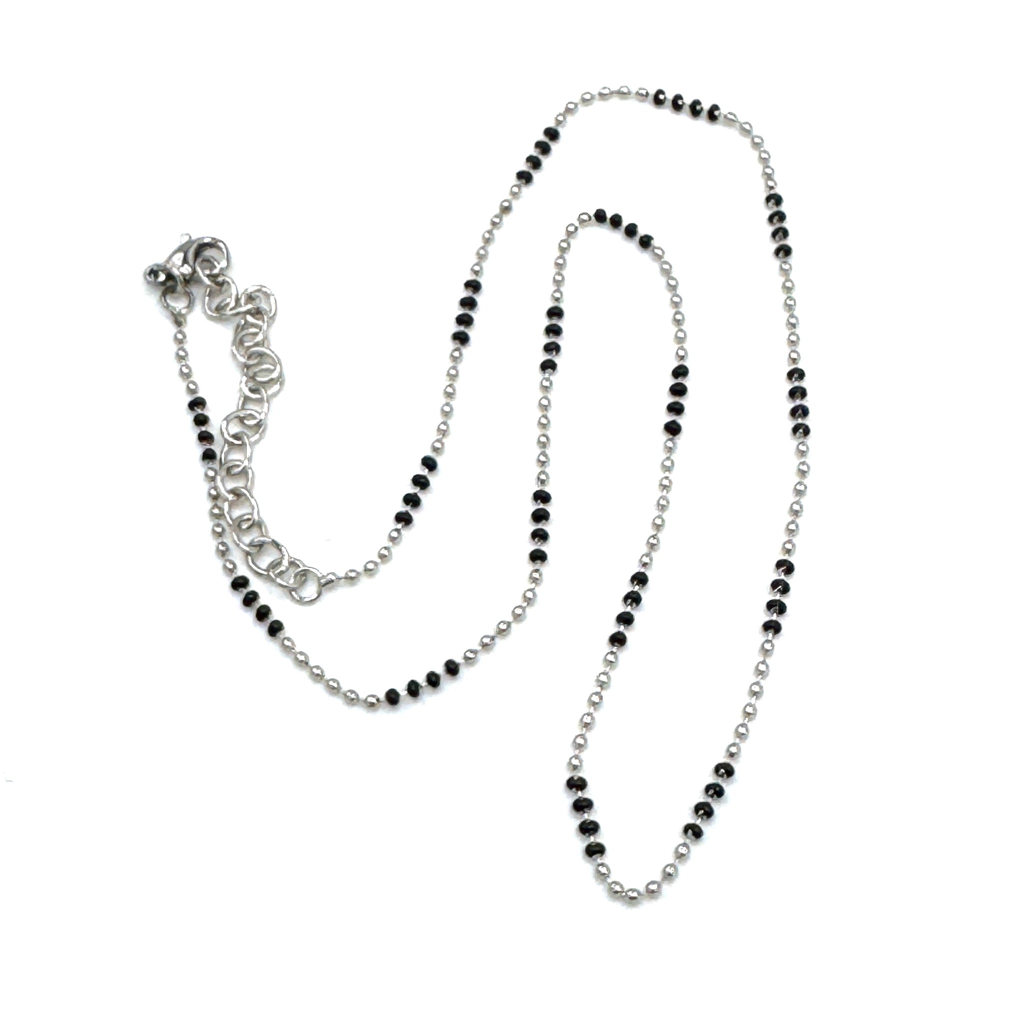 Silver necklace with black beads on a white background