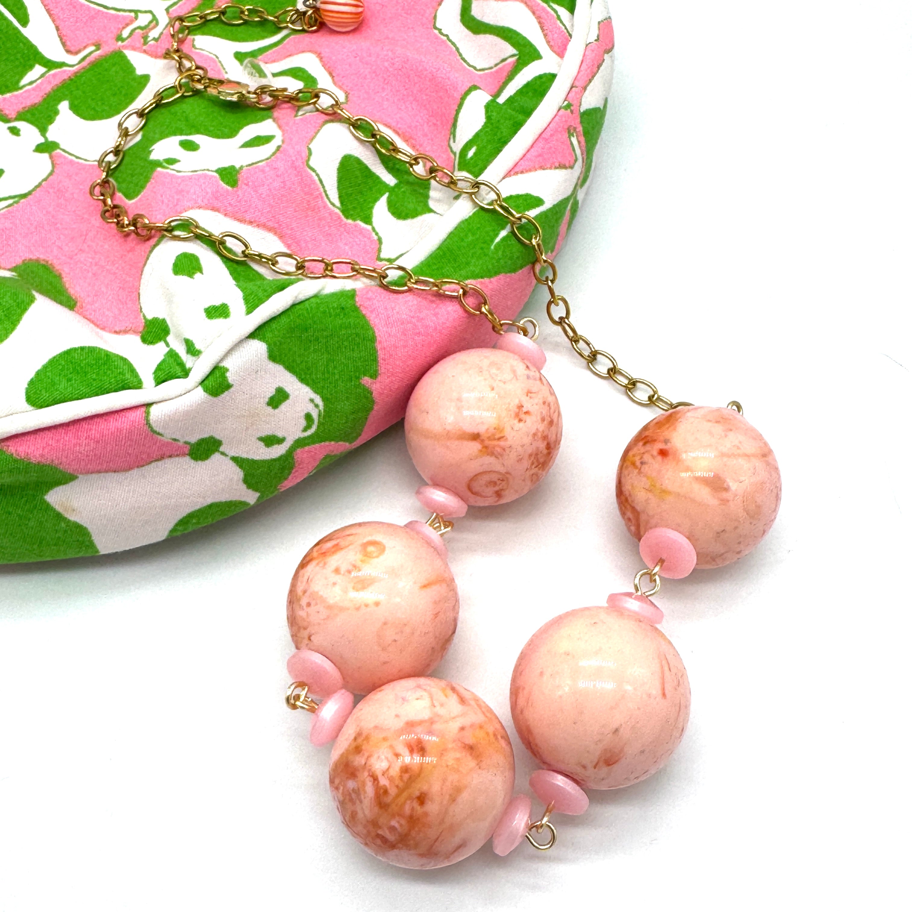 Necklace with pink and gold beads on a white background