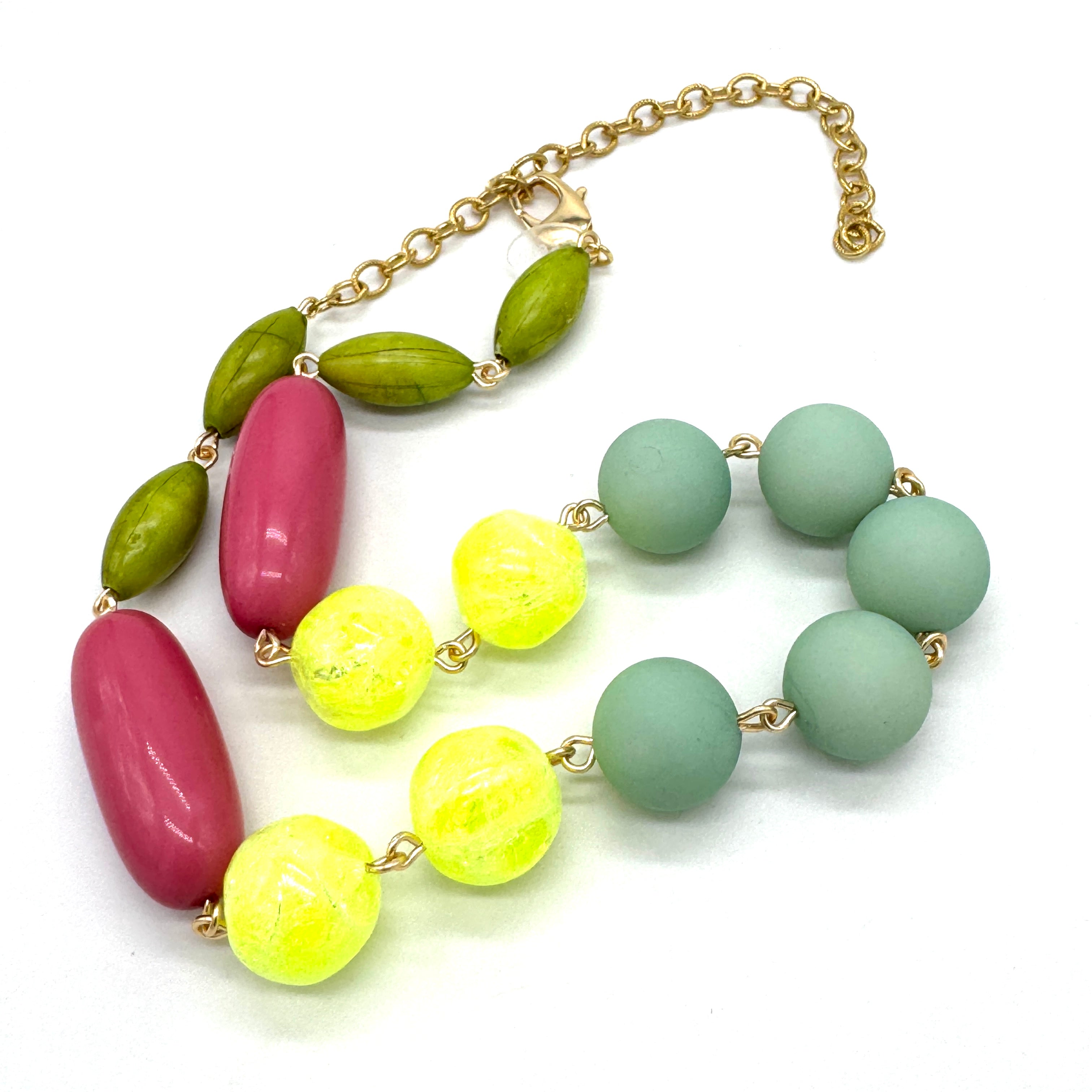 Colorful beaded necklace with gold chain on a white background