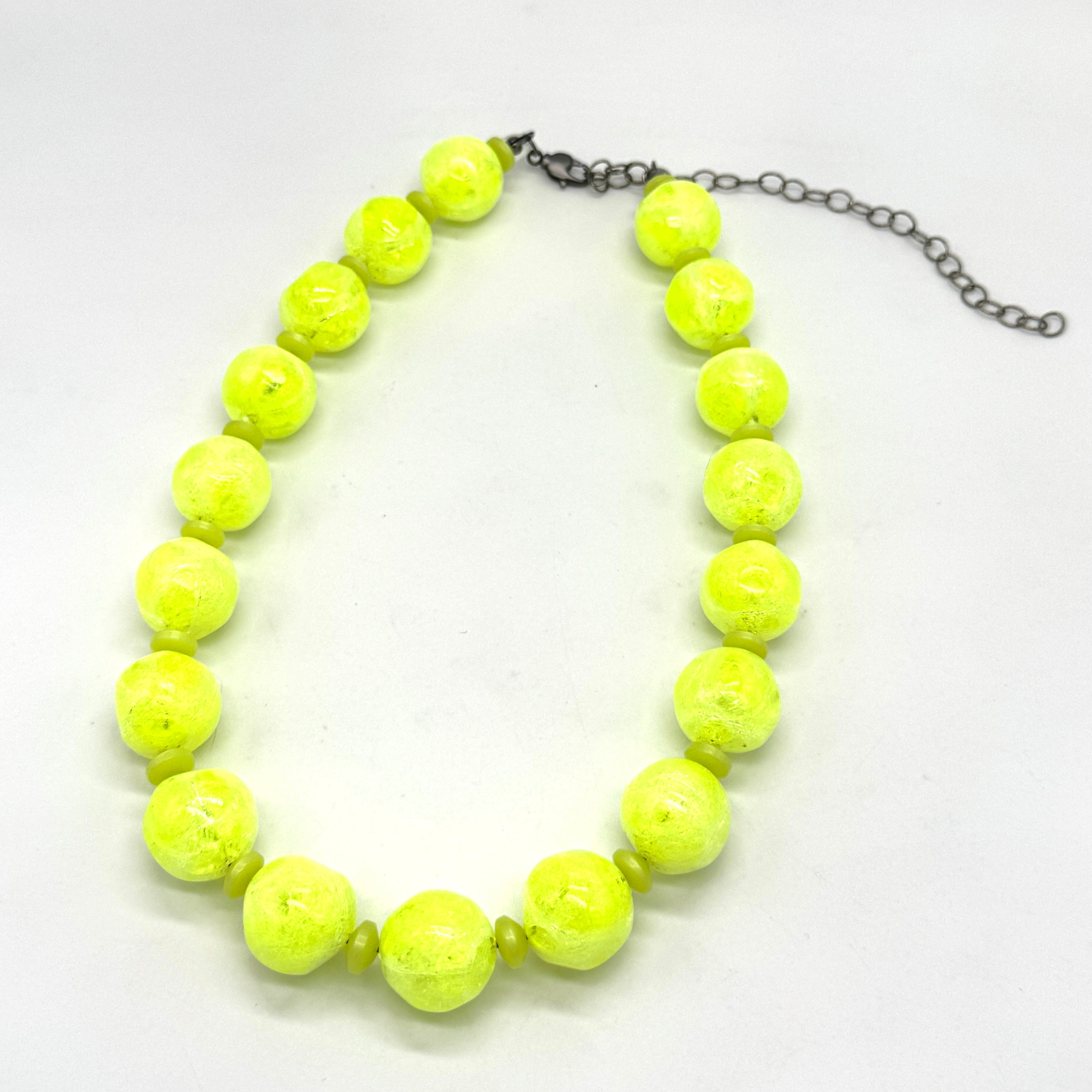 Neon yellow beaded necklace on a white background