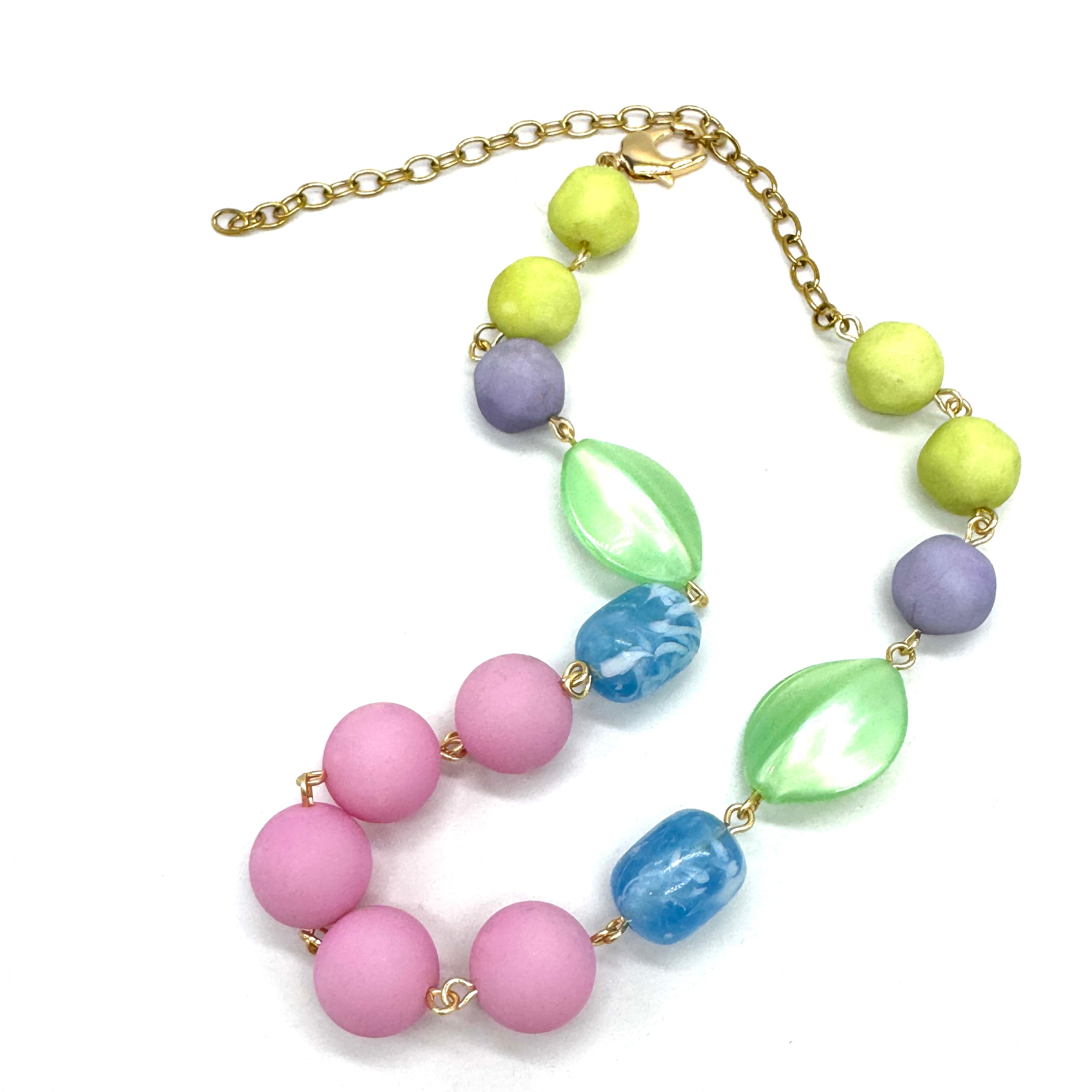 Colorful beaded necklace with gold chain on a white background