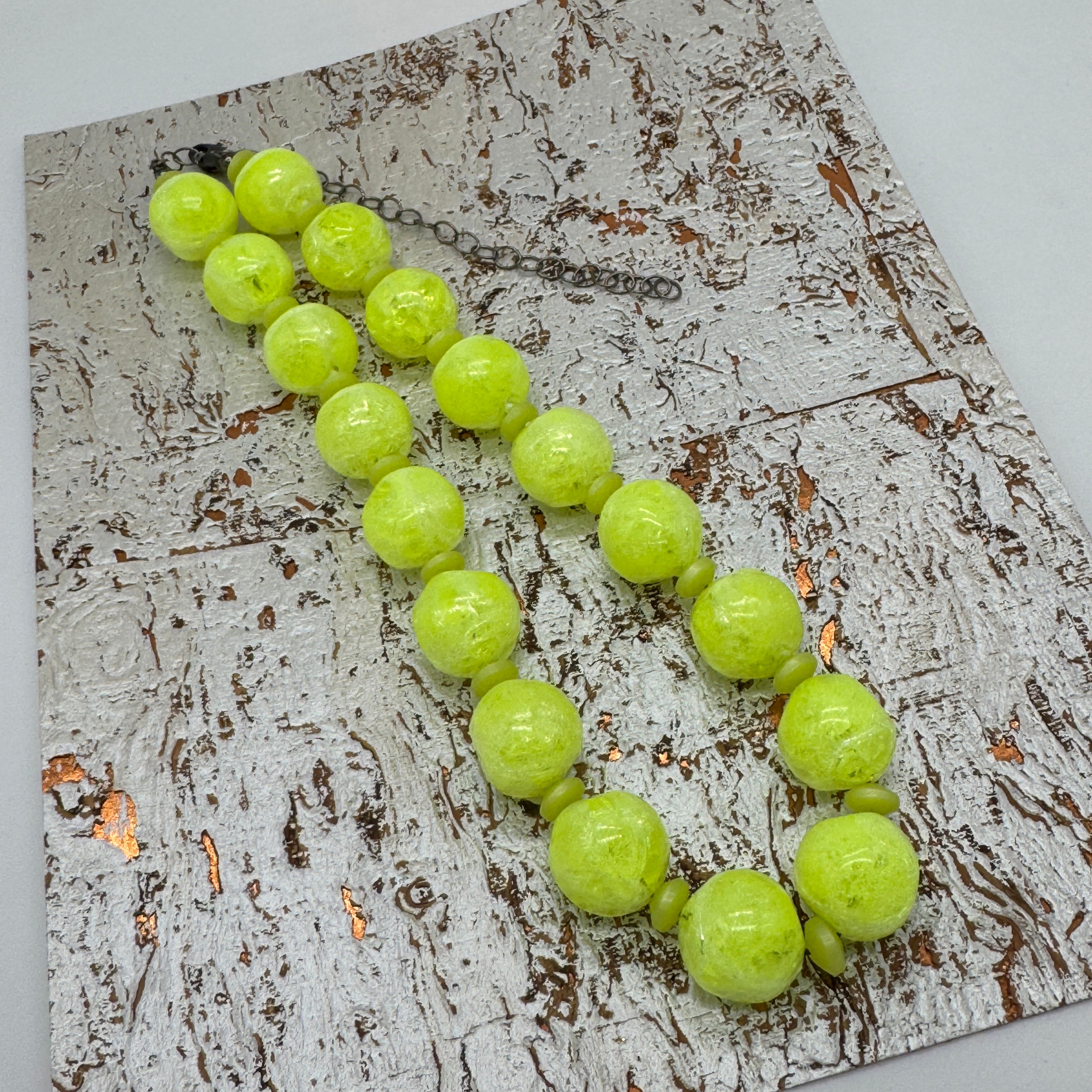Neon yellow beaded necklace on a textured surface
