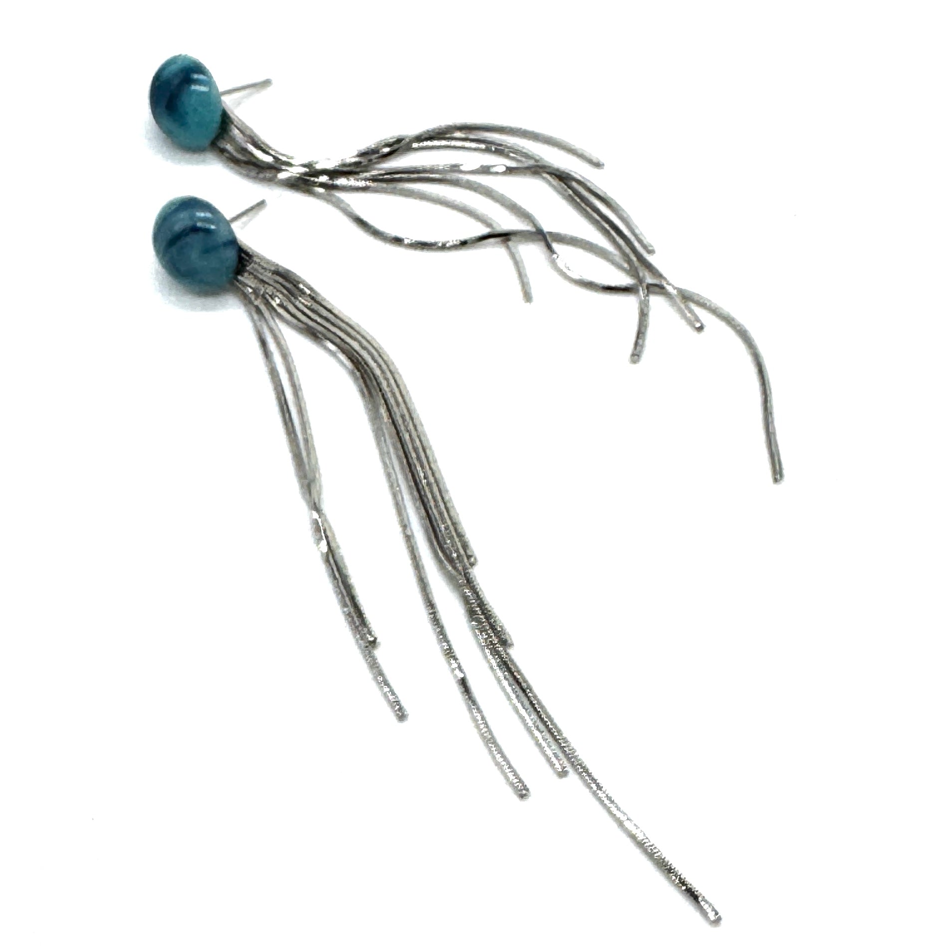 Pair of silver fringe earrings with blue tops on a white background