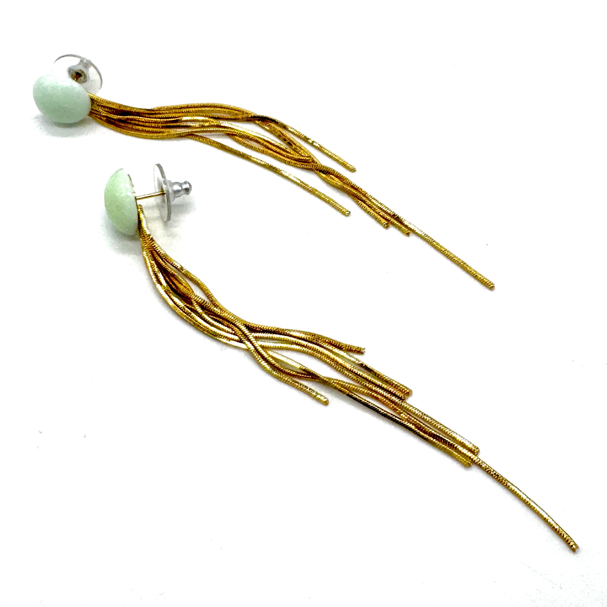 Gold tassel earrings with a light green bead on a white background