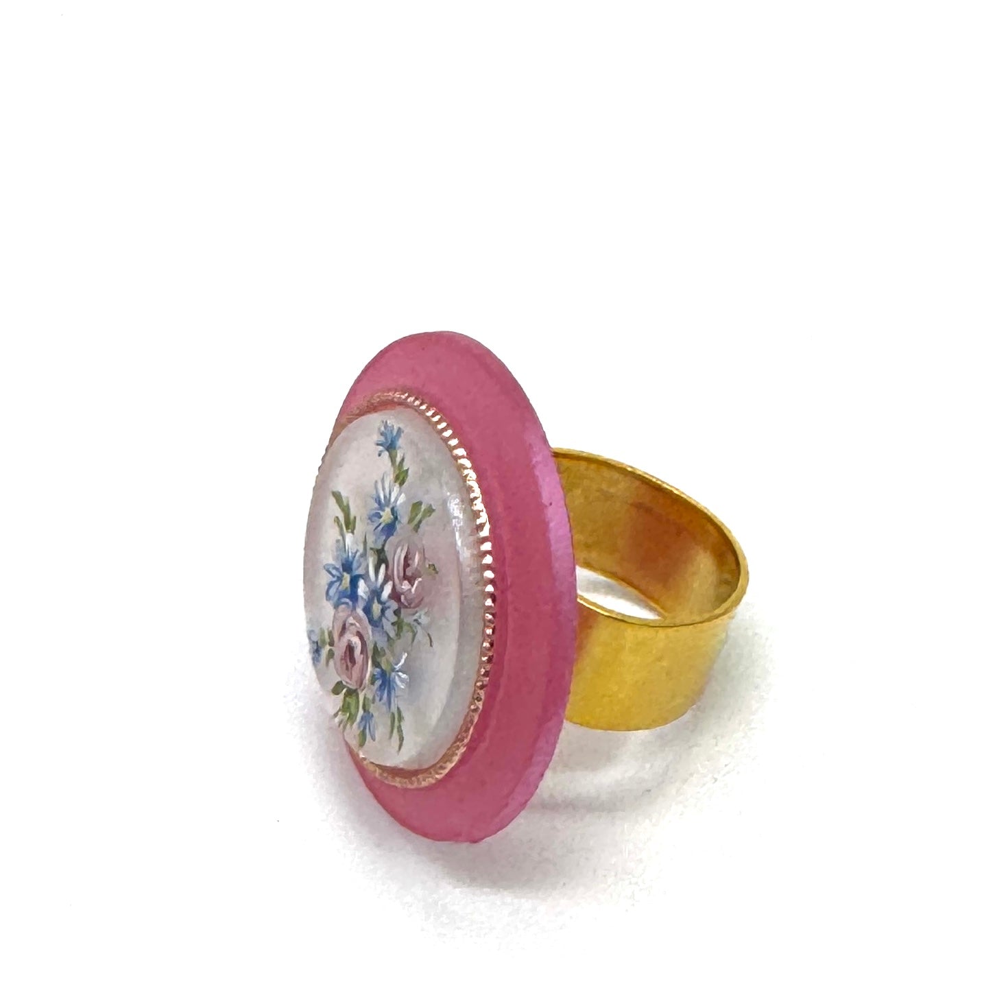Gold ring with a pink border featuring floral design on a white background