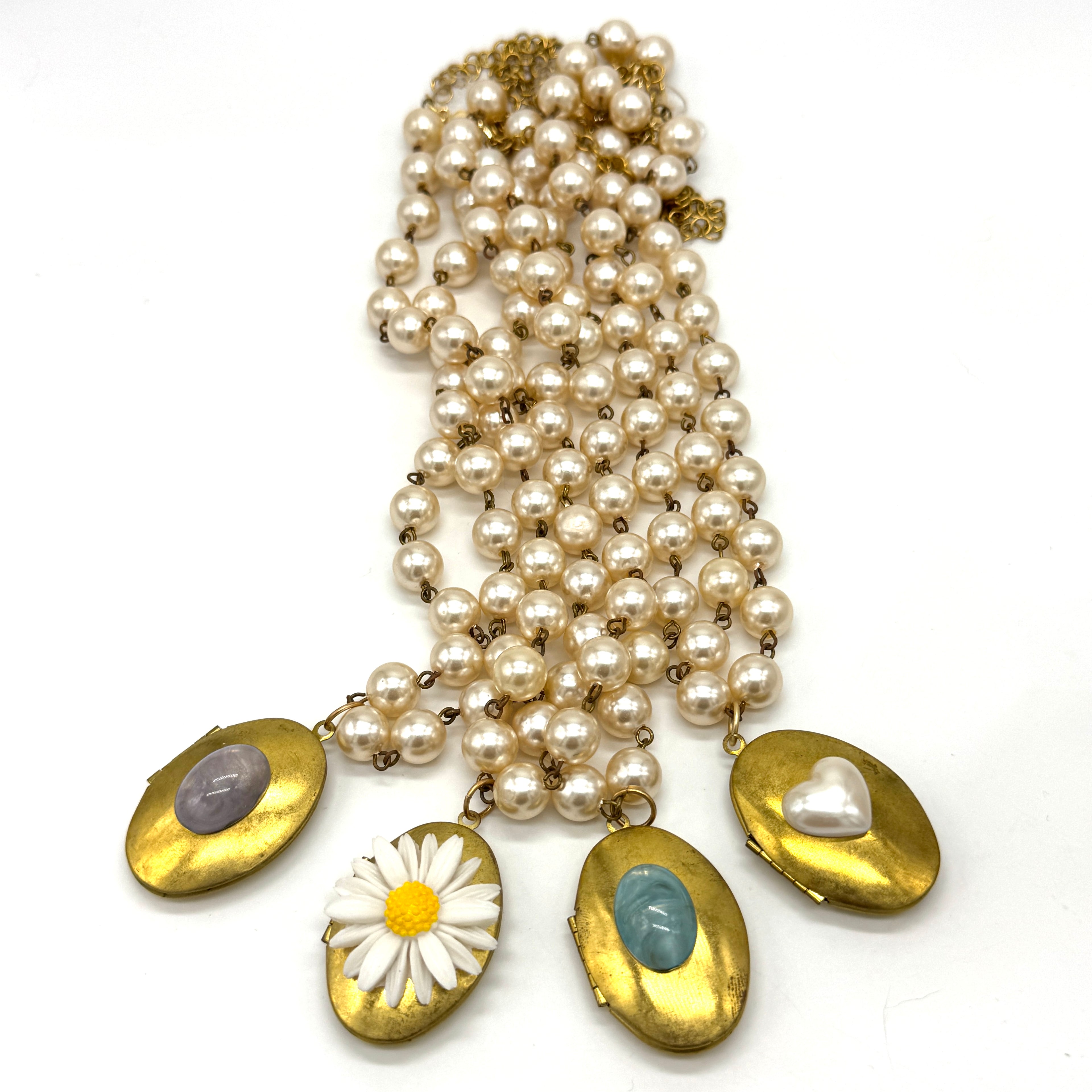 Pearl necklaces with gold locket pendants featuring on a white background