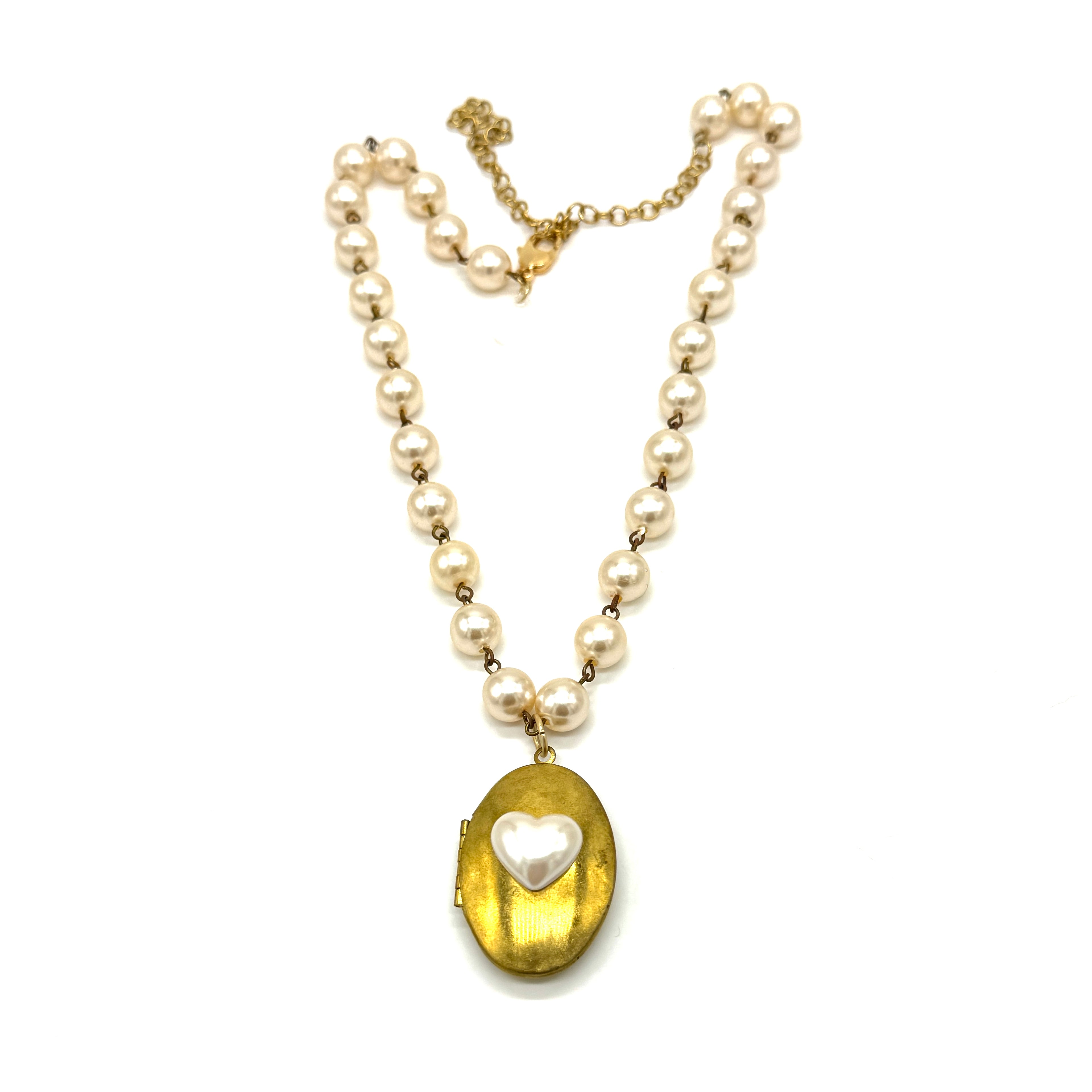 Pearl necklace with a gold locket featuring a heart pendant on a white background