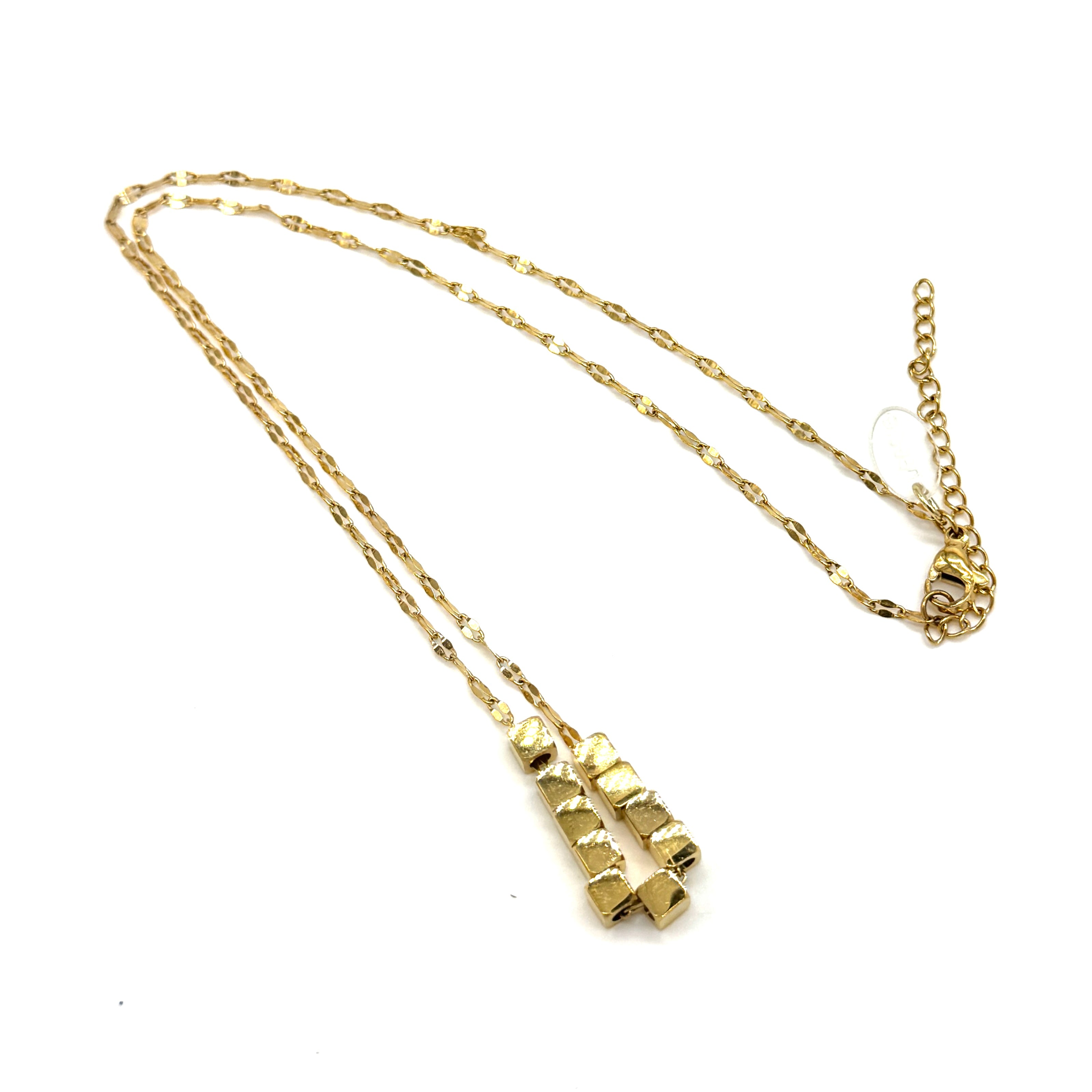 A gold necklace on a white background. It is a fine chain with several cube beads at the center.