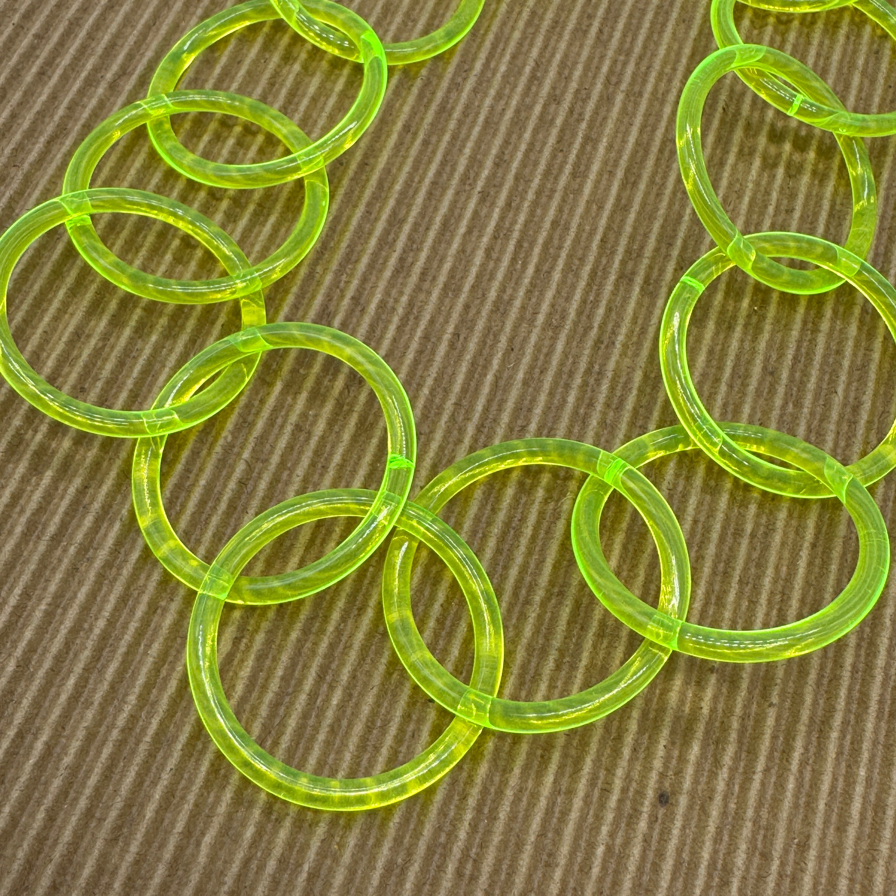 Close up of an adjustable necklace featuring large lucite chain links in a neon yellow