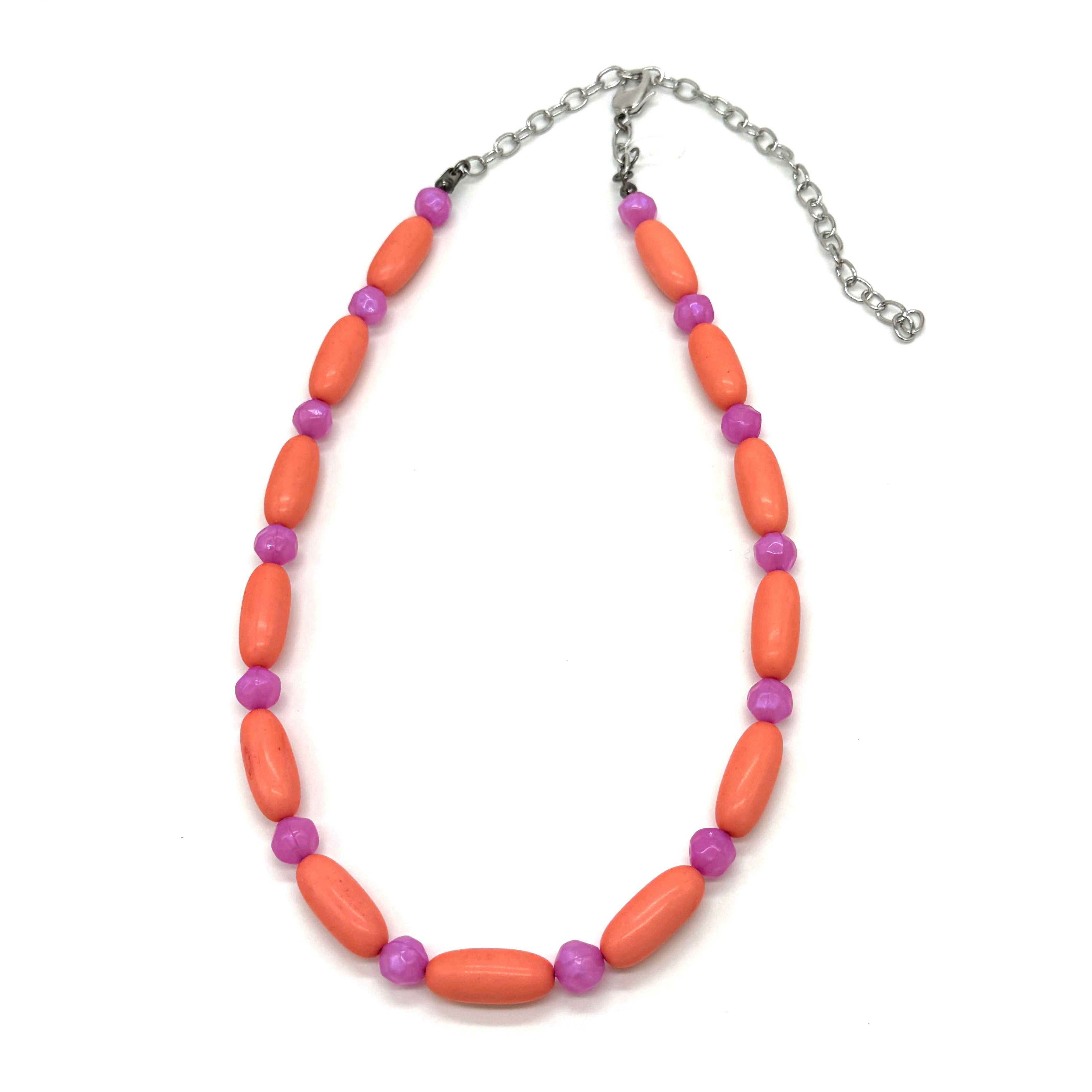 Bright coral and pink beaded necklace on a white background.