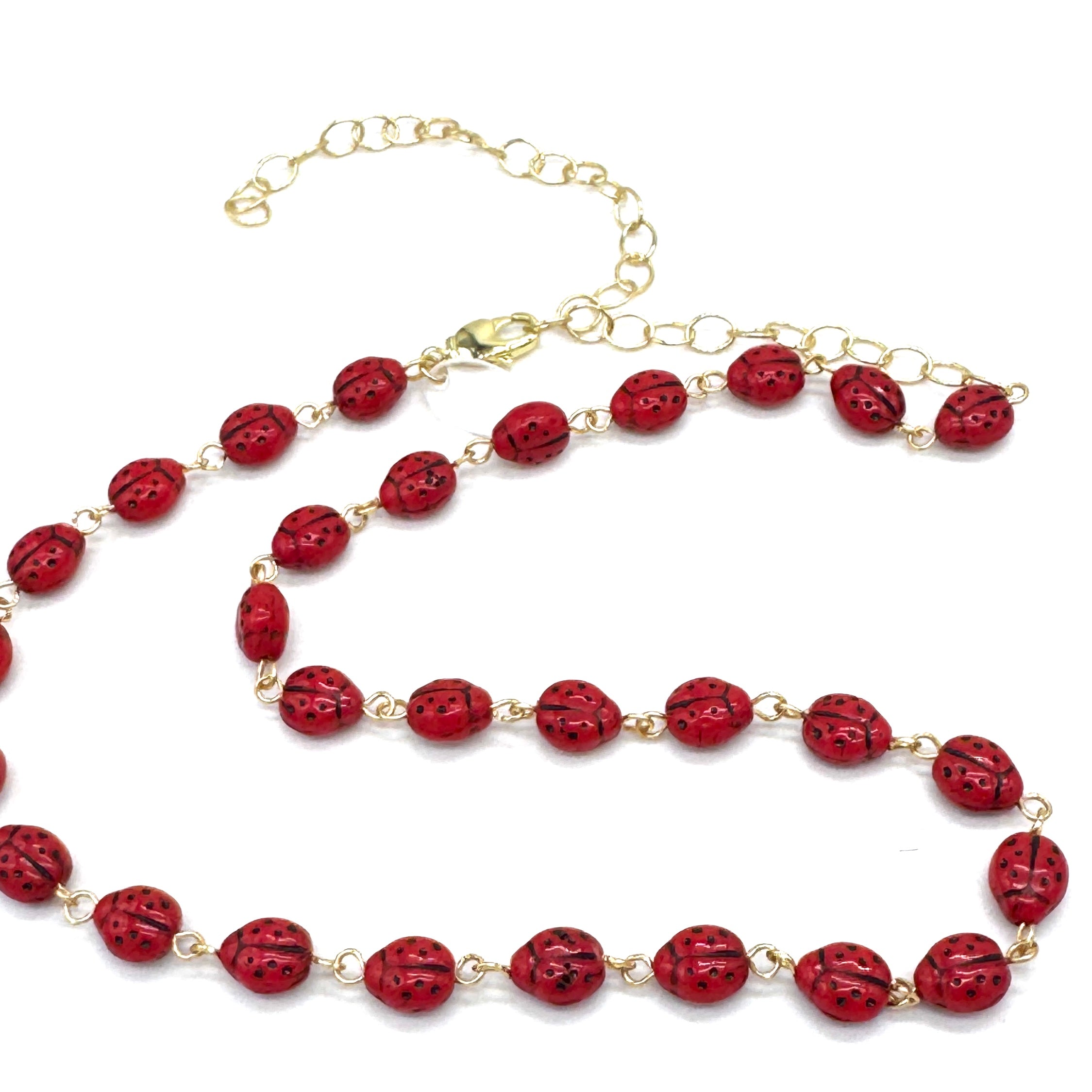 Necklace with red beads and gold chain on a white background