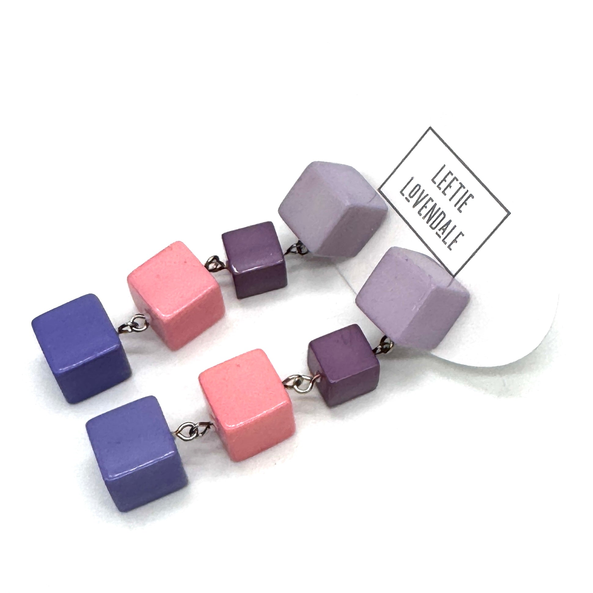 Colorful cube-shaped beaded earrings on a white background with &