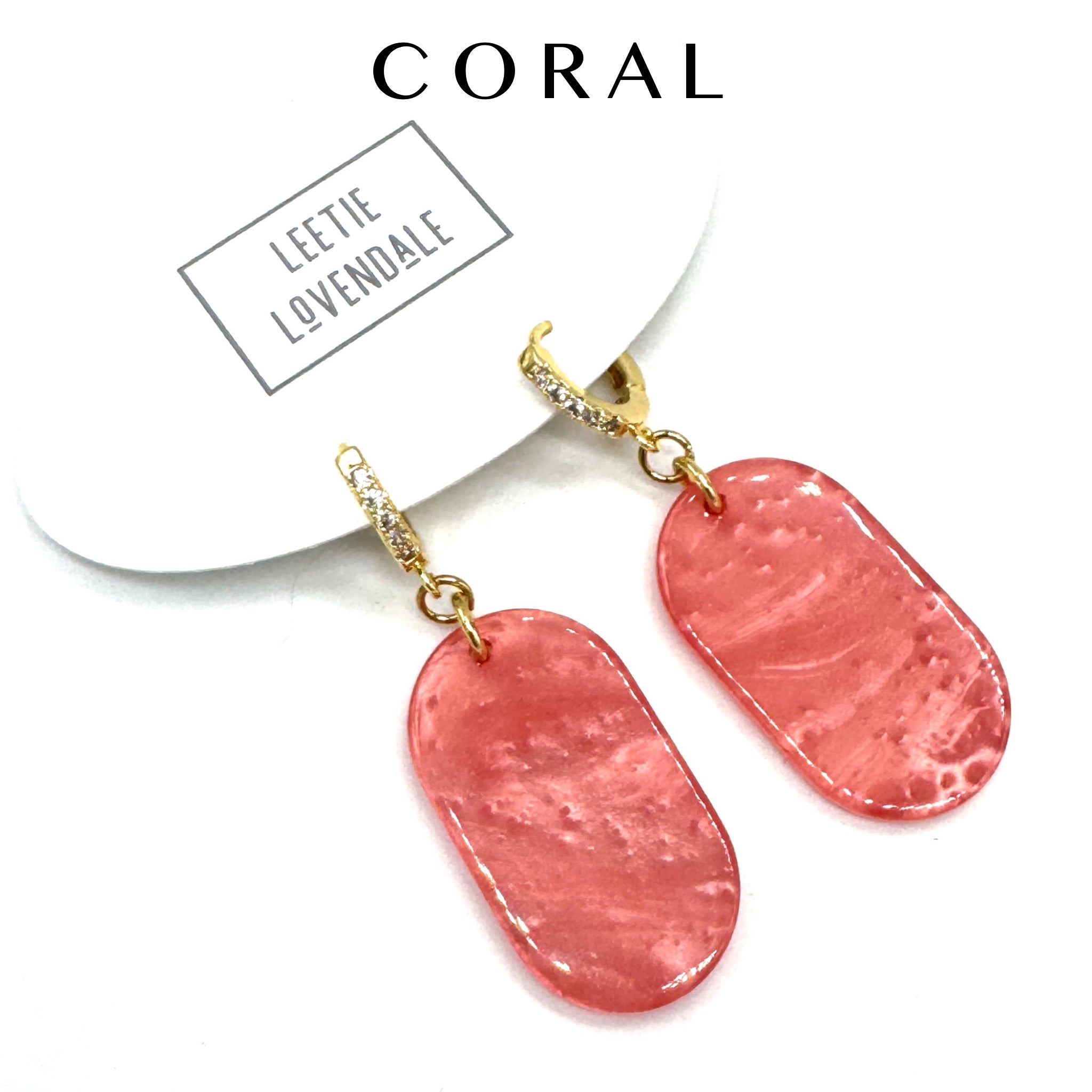 Pink earrings with gold hooks on a white background, featuring the brand &