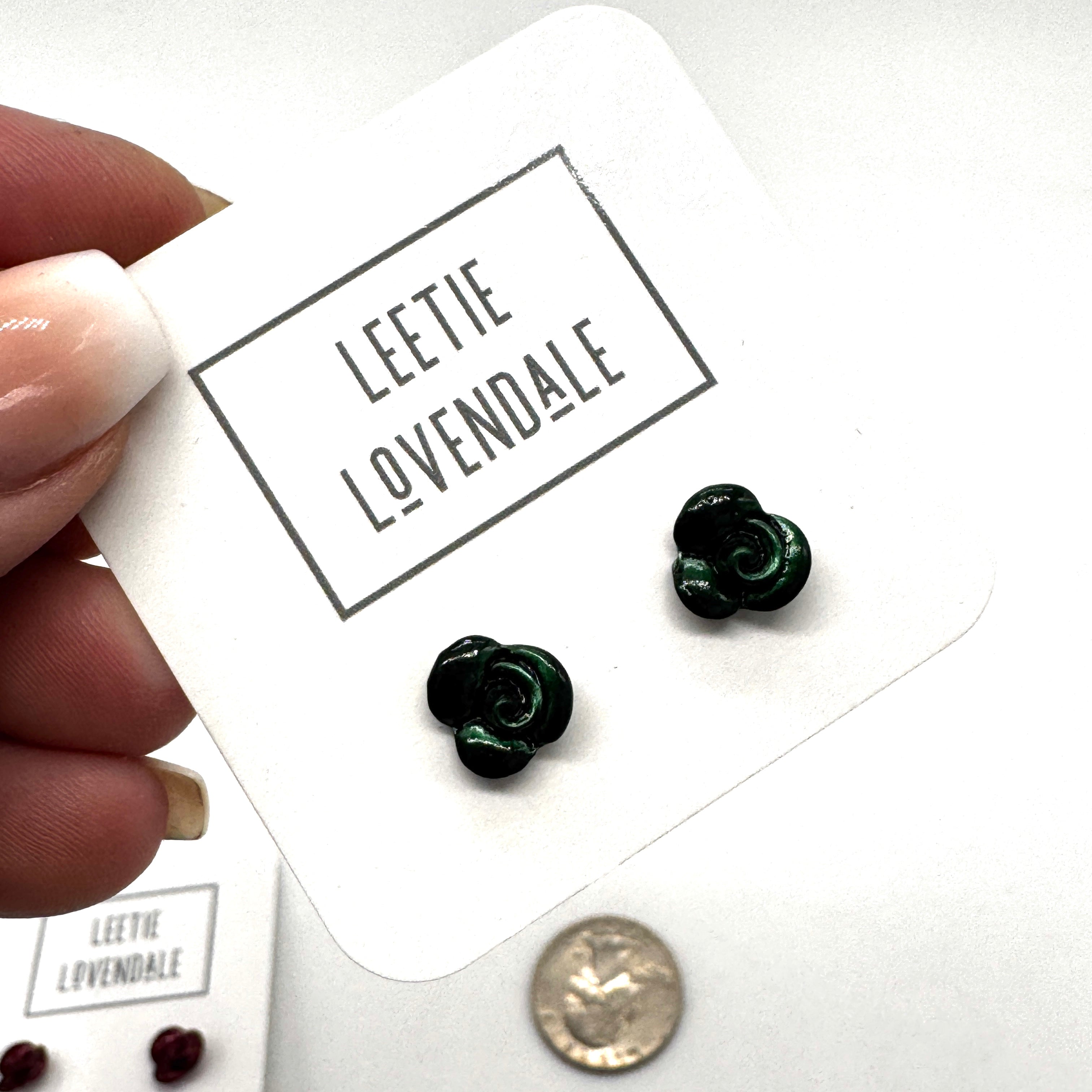 Green flower-shaped earrings on a card with &
