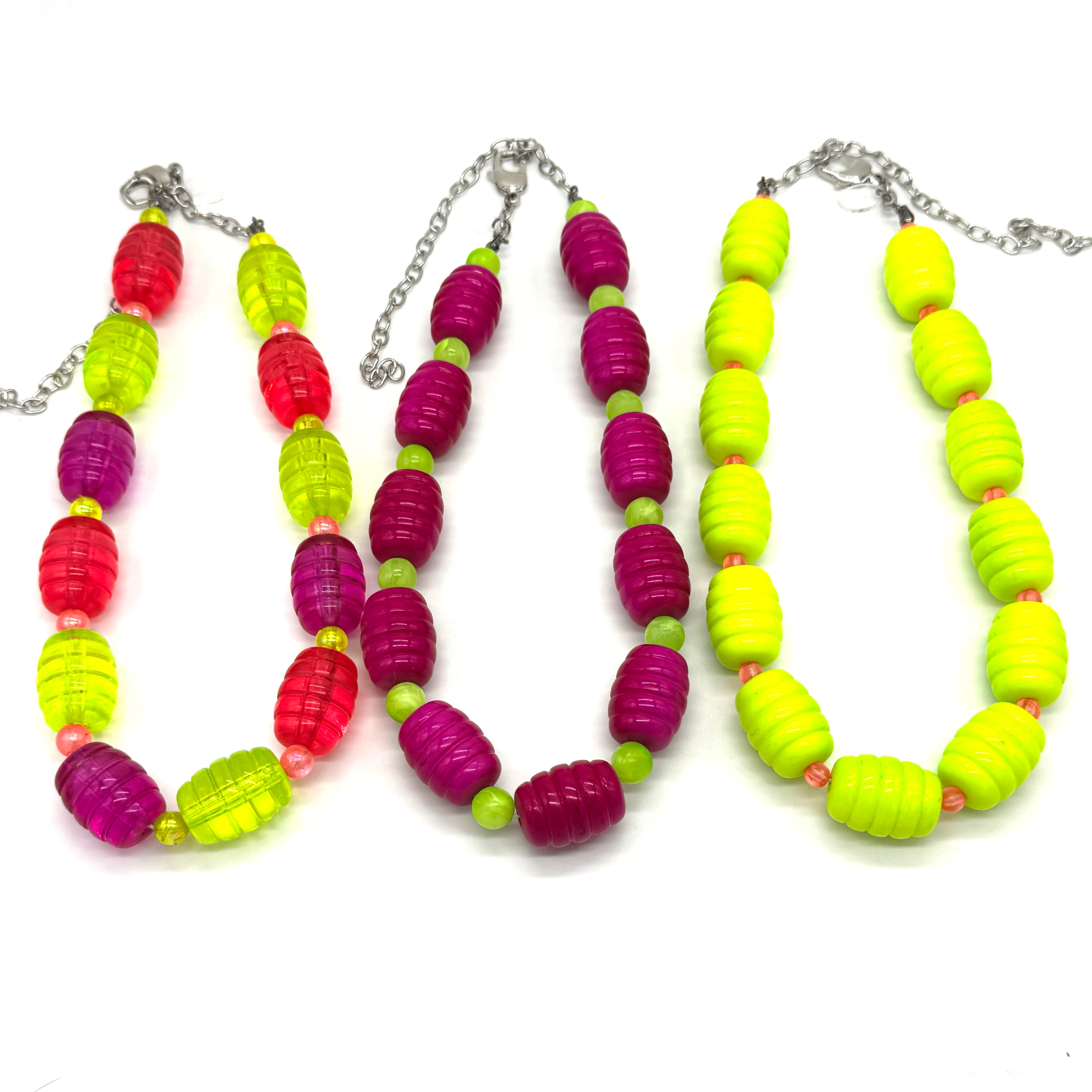 Colorful beaded necklaces with red, green, and purple beads on a white background.