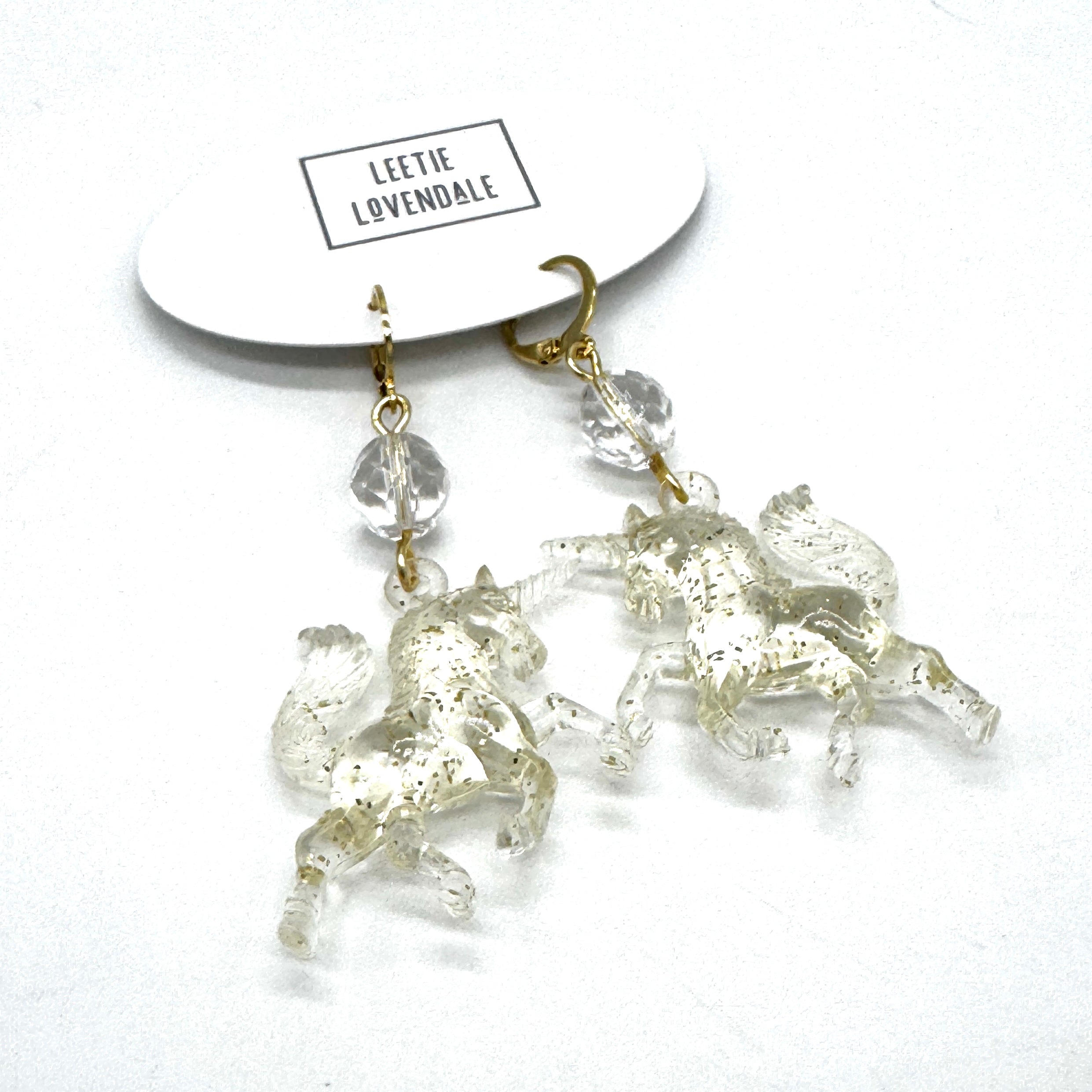 Crystal horse earrings on a white background with &