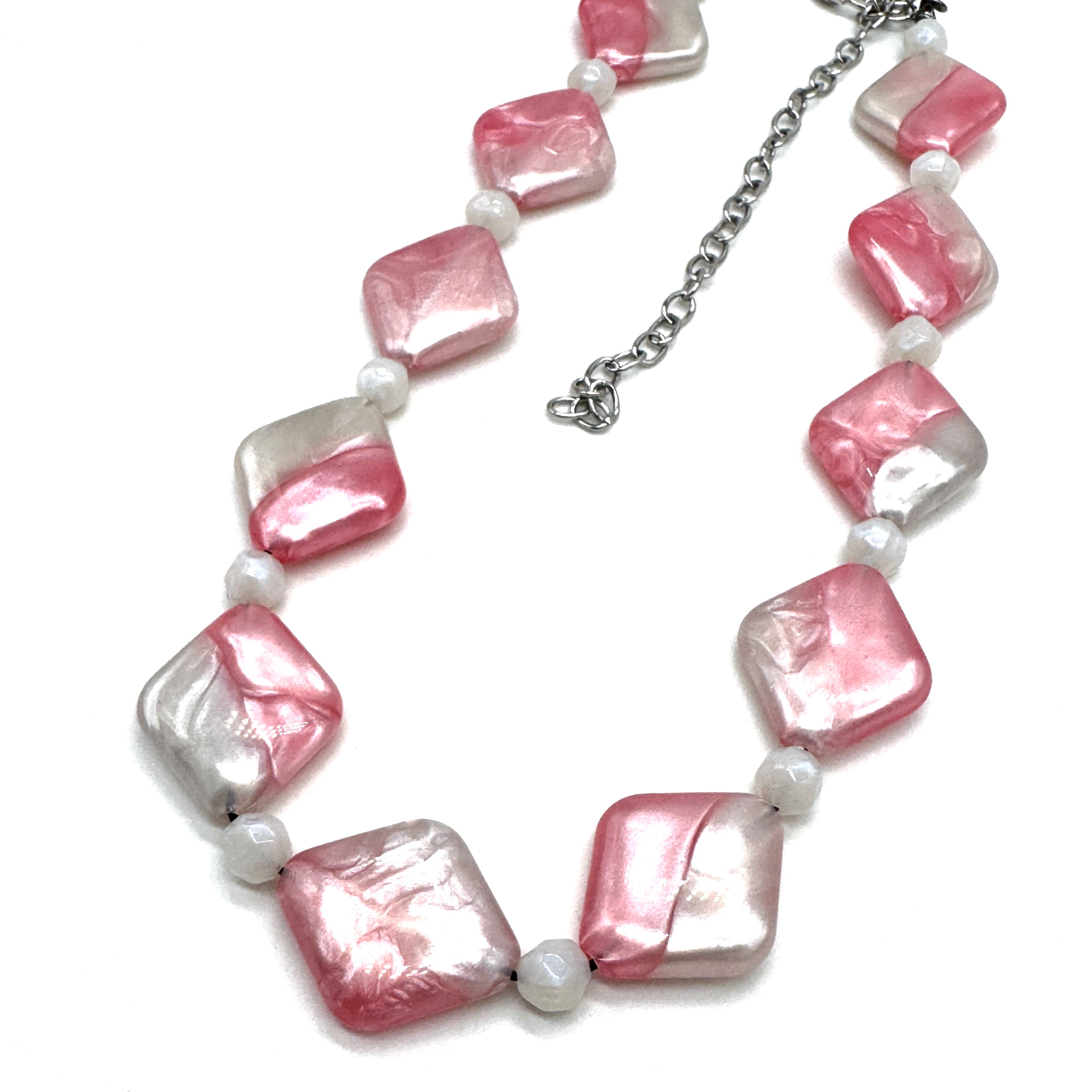 Necklace with pink and white beads on a white background
