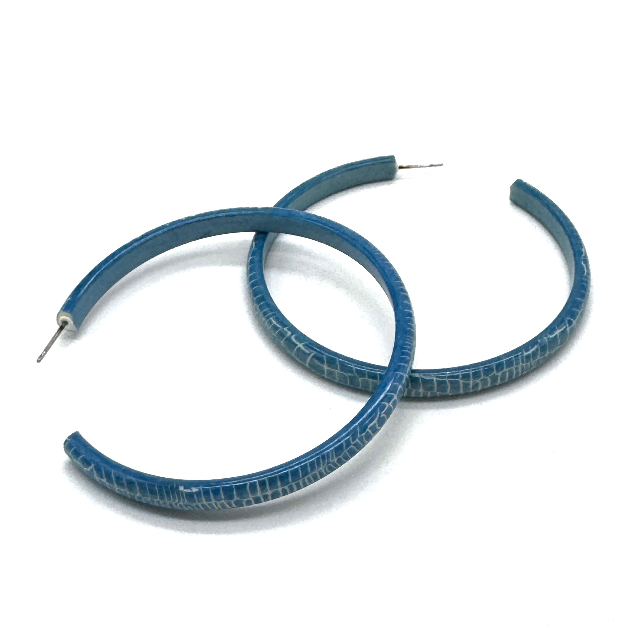 Large crackled blue lucite hoop earrings.