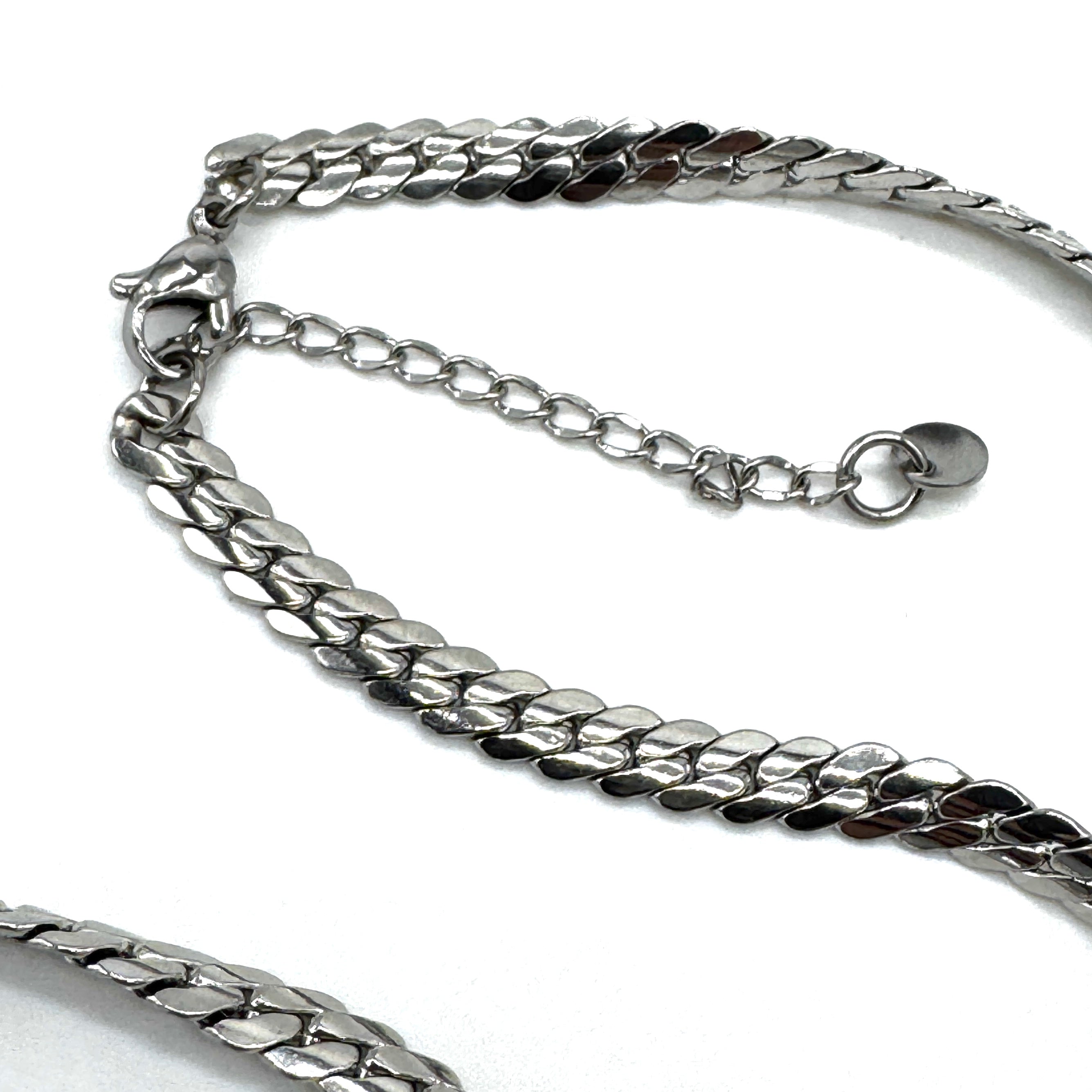 Closeup of clasp on an adjustable silver snake chain necklace.