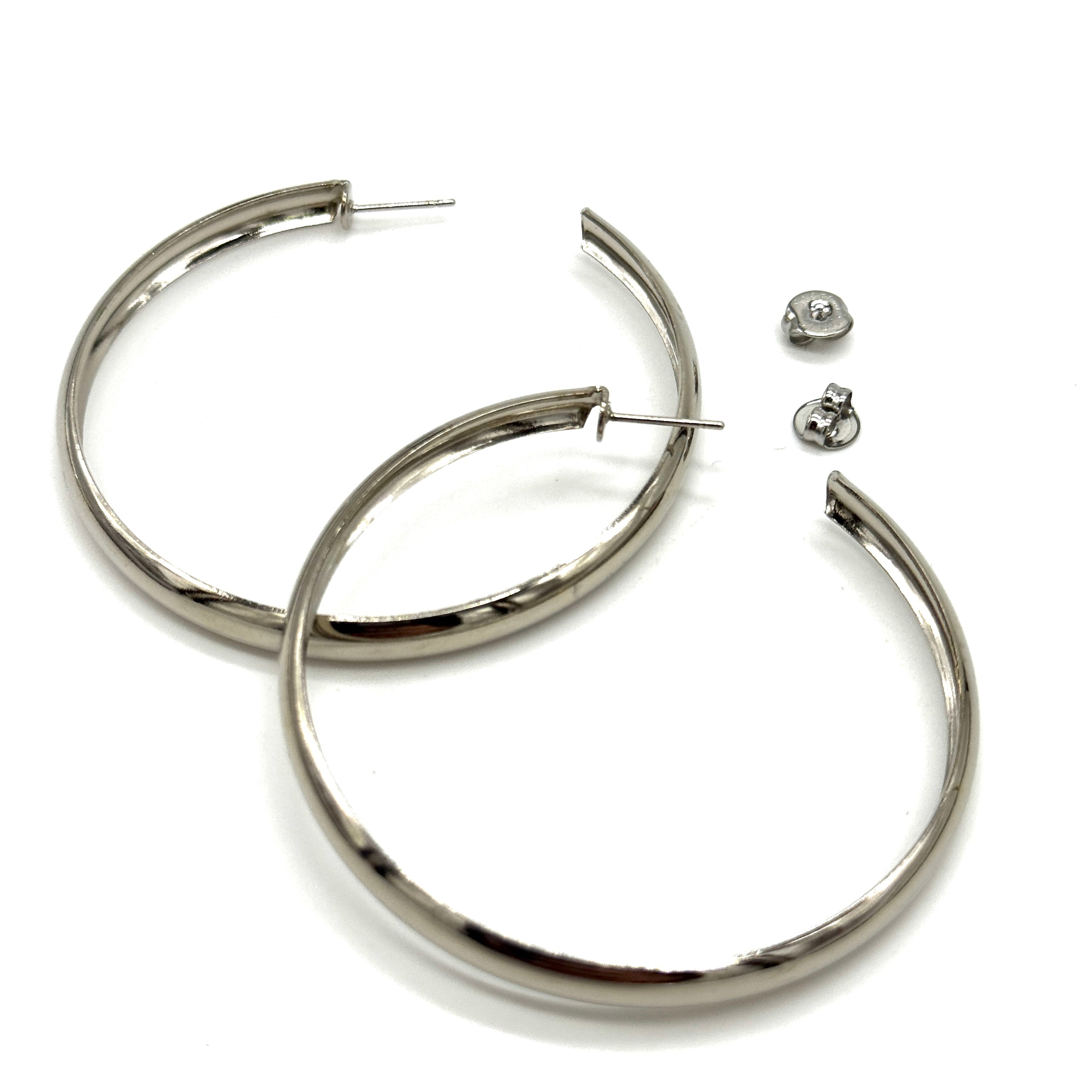Large silver hoop earrings on a white background.