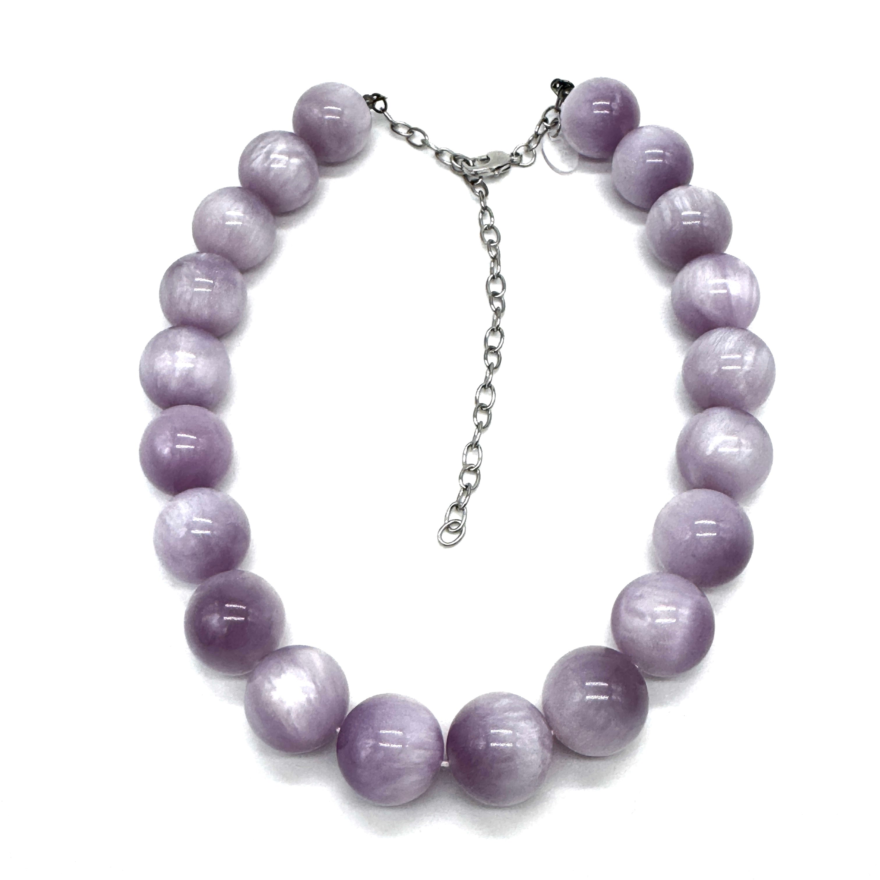 A beaded necklace made of smooth, round lavender-purple beads with a silver-tone chain extender clasp, displayed on a clean white background.