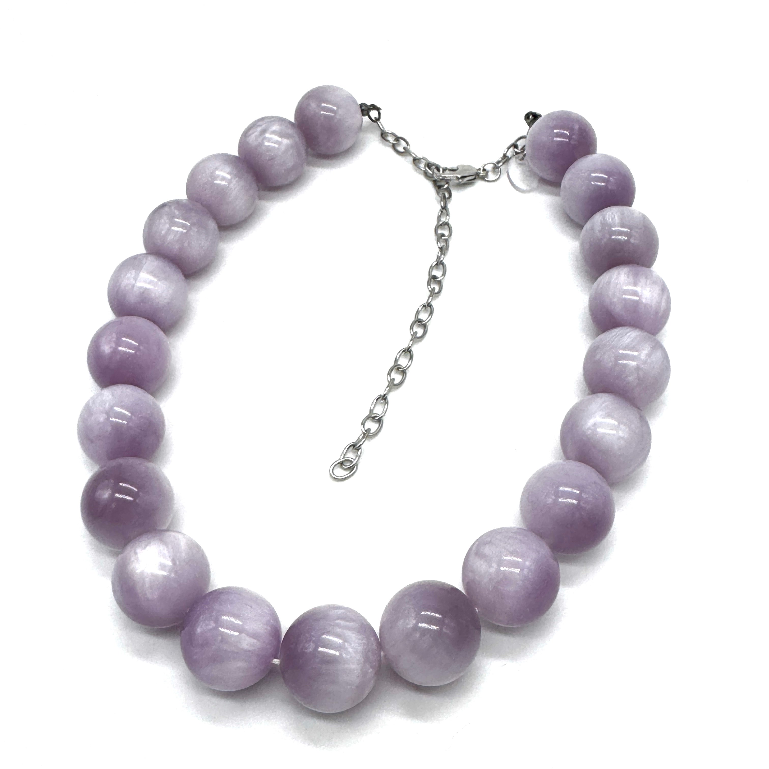 A beaded necklace made of smooth, polished lavender-purple round beads with a silver-tone chain extender clasp, displayed on a clean white background.
