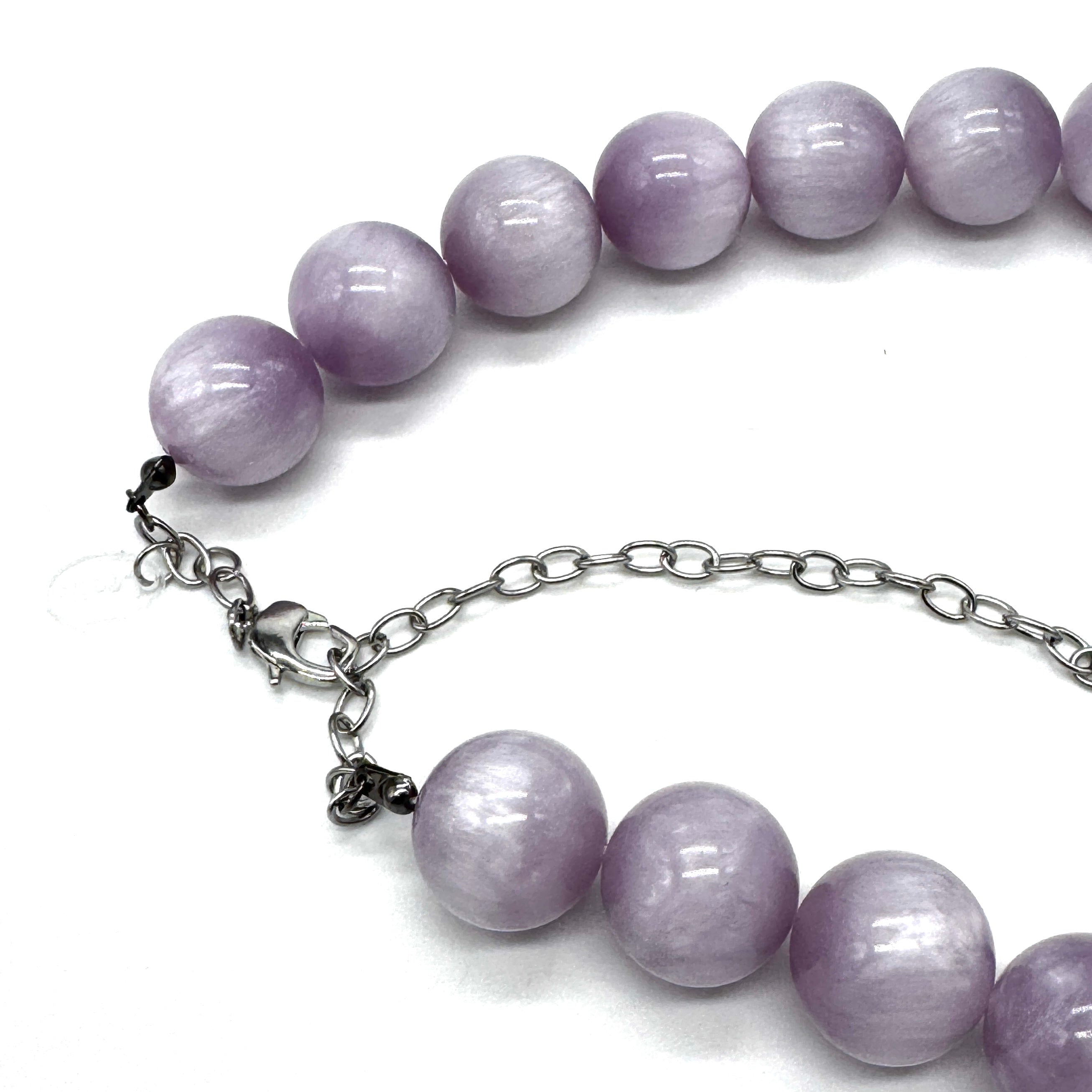 A beaded necklace with smooth, round lavender-purple beads and a silver-tone chain extender clasp, shown on a plain white background.