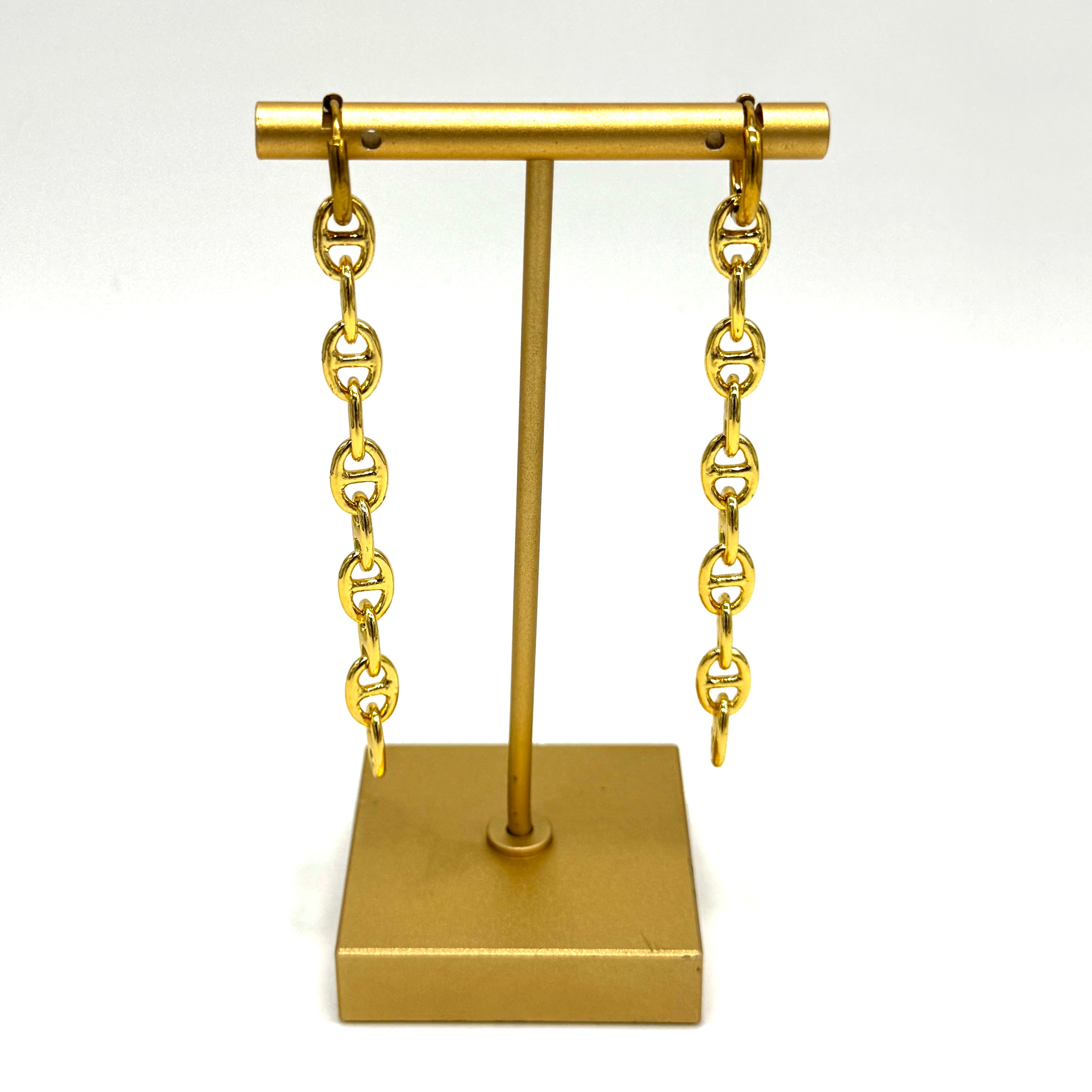 Gold-tone chain drop earrings displayed on a matching gold jewelry stand against a plain white background.