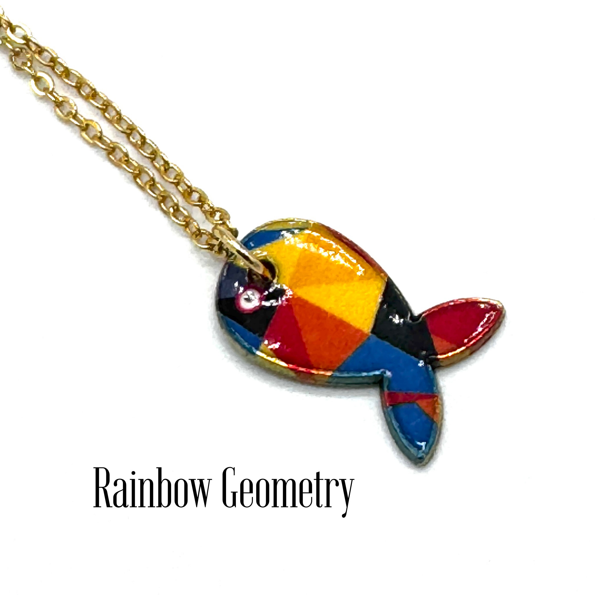 A gold chain necklace with a colorful fish-shaped pendant featuring a geometric rainbow pattern of red, orange, yellow, blue, and black, displayed on a white background with the text &