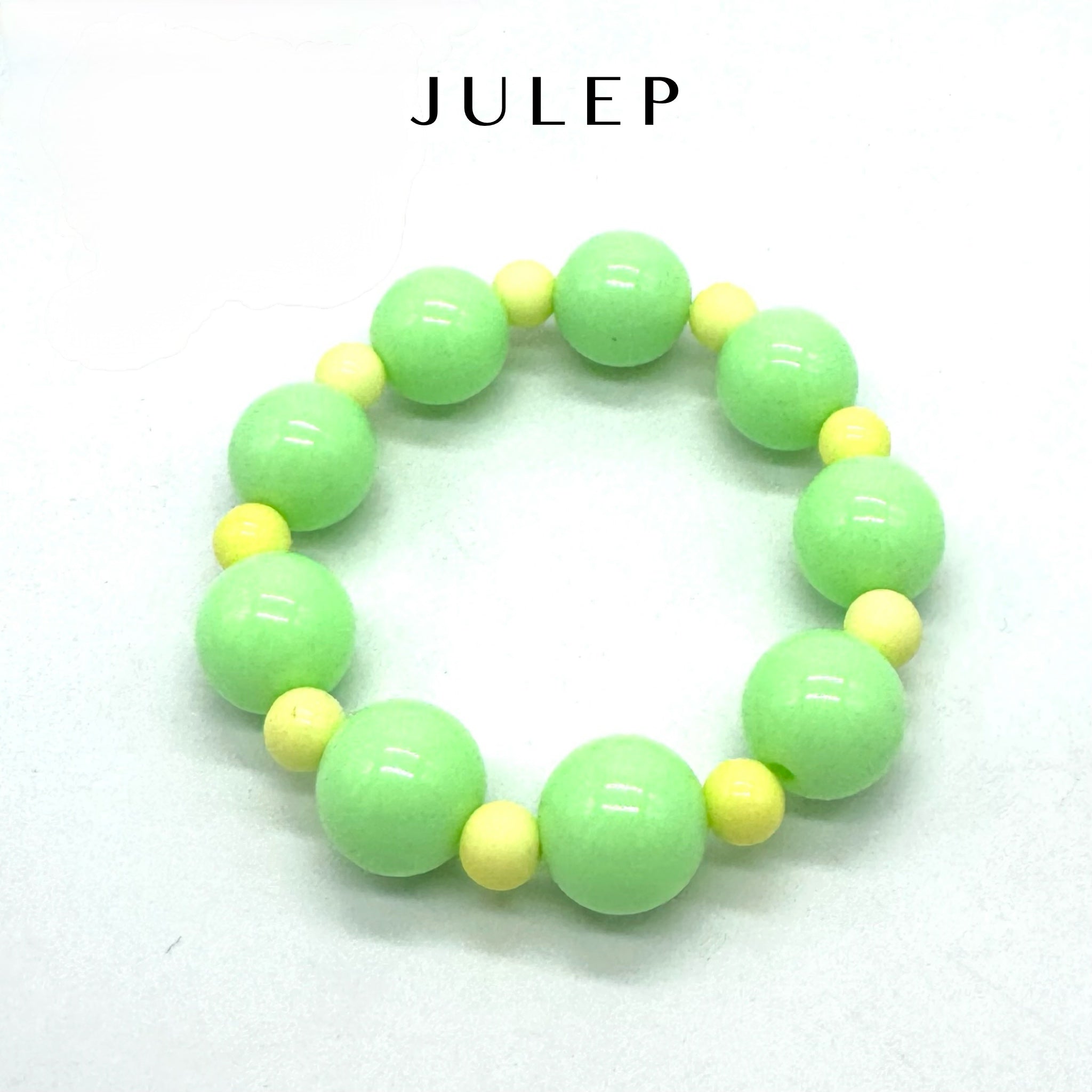 Green and yellow beaded bracelet on a white background with &
