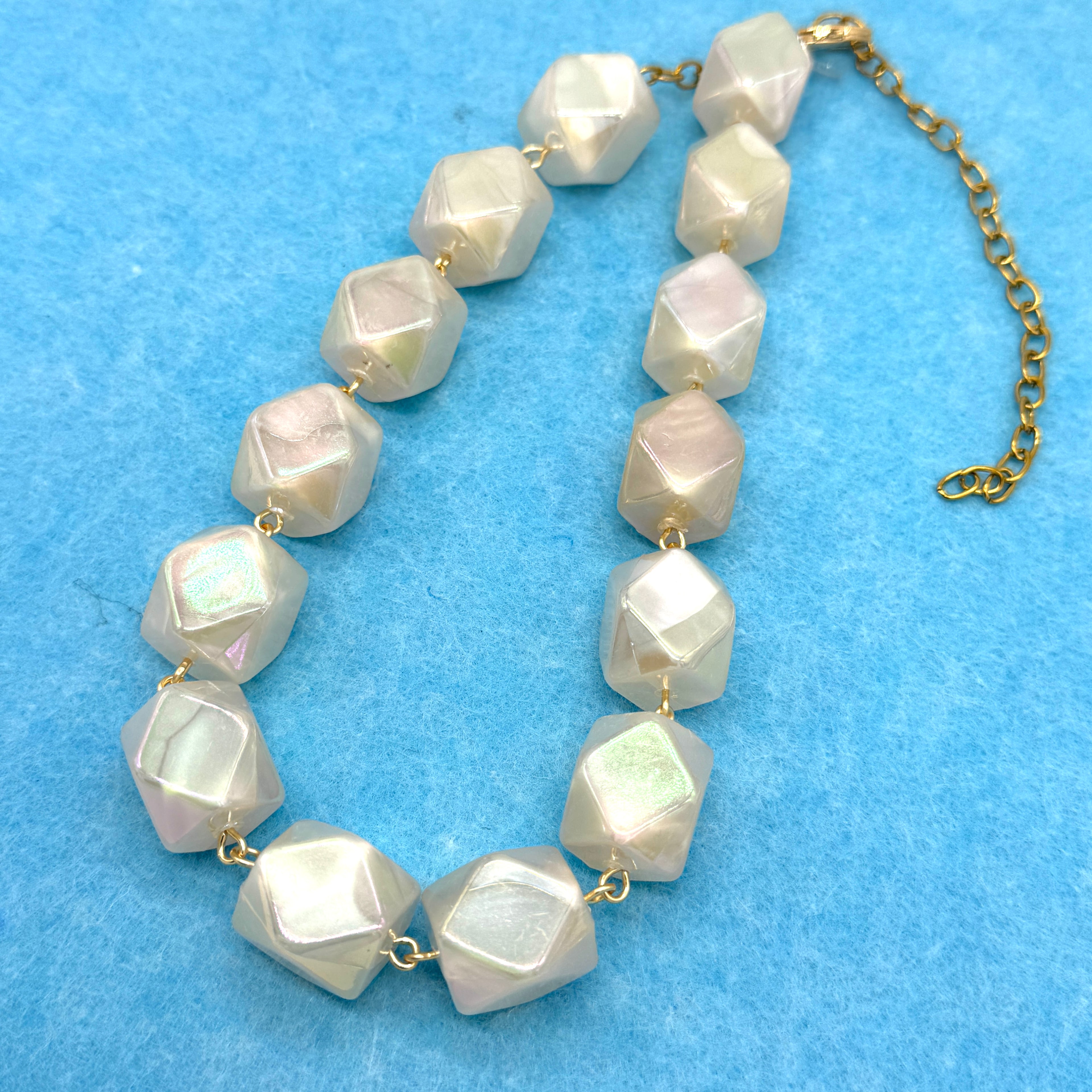 Necklace with large faceted beads on a blue background
