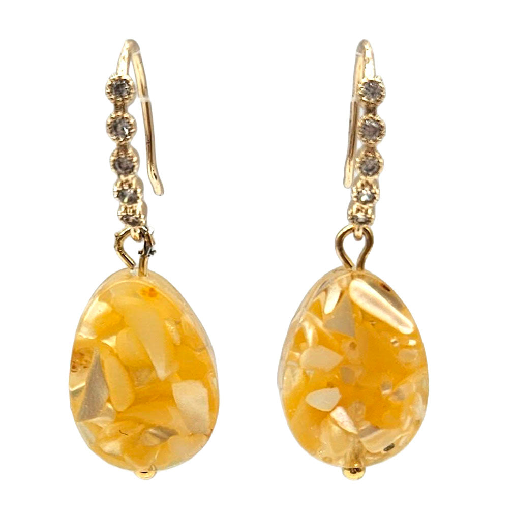 Gold earrings with amber-colored stones on a white background