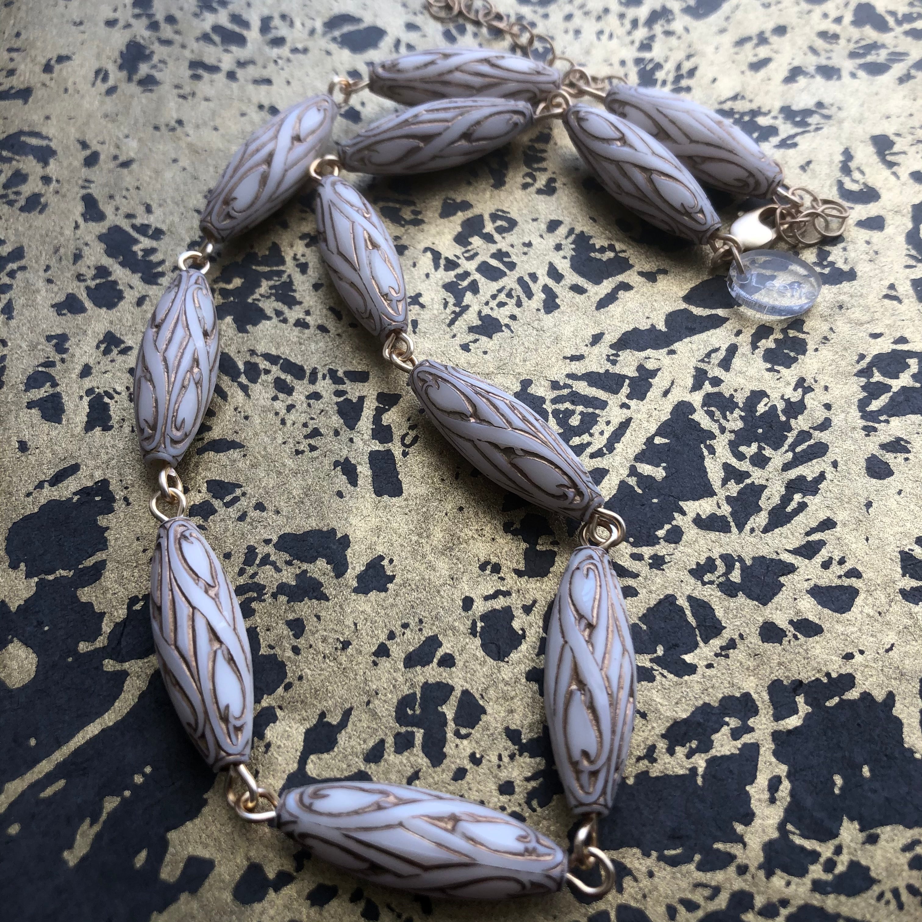 gold and white necklace