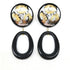 Pair of earrings with black oval drops and floral designs in gold and silver on a white background